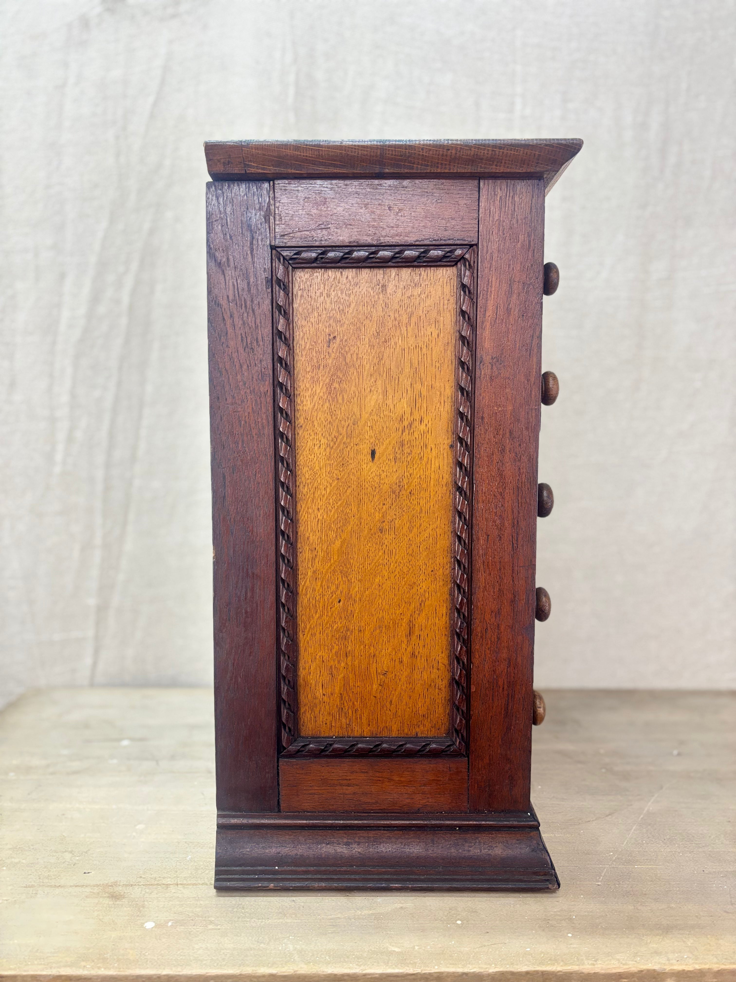 Wooden jewelry box with a central panel on a light background