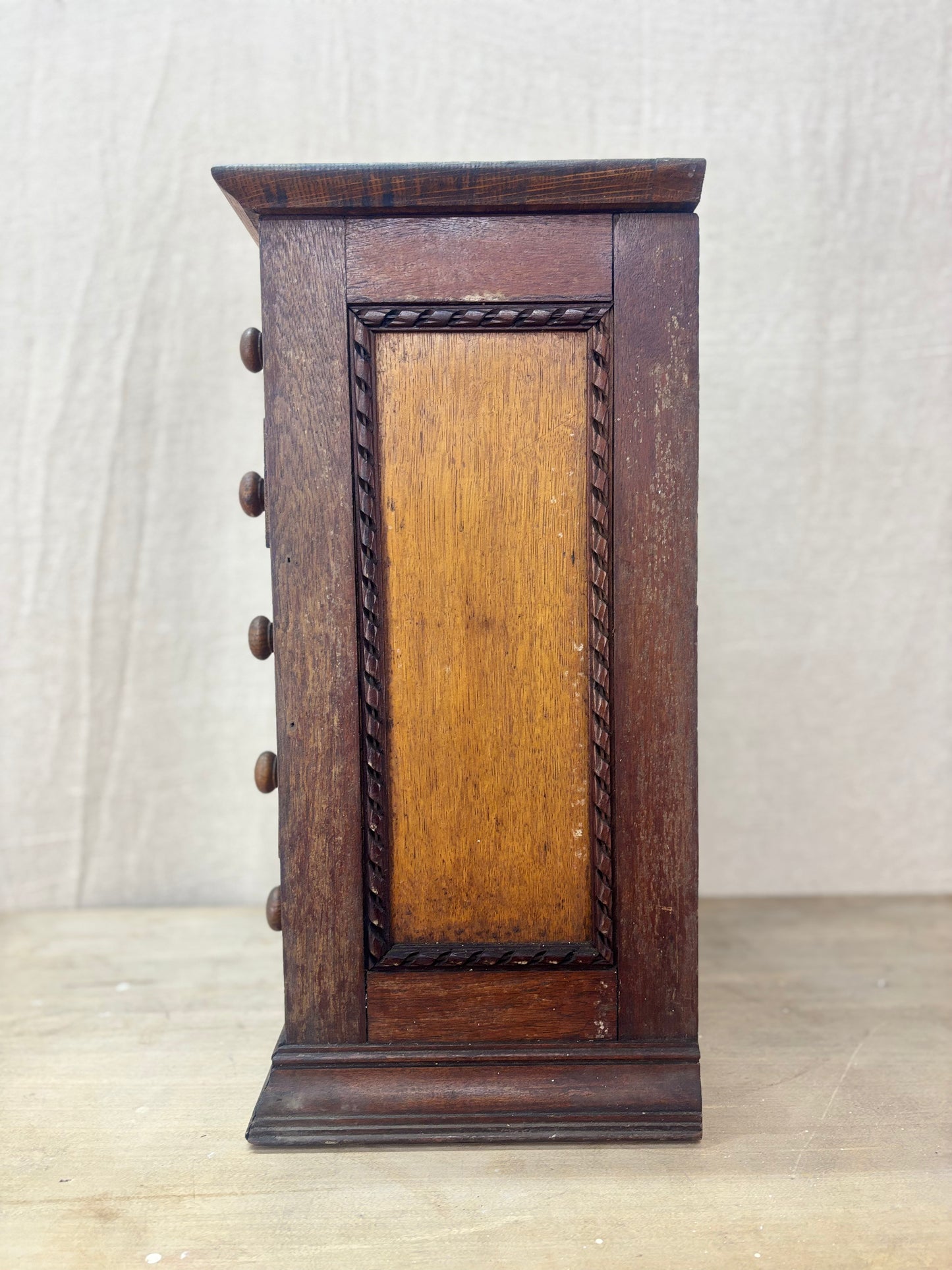 Wooden jewelry box with a decorative front panel on a light background