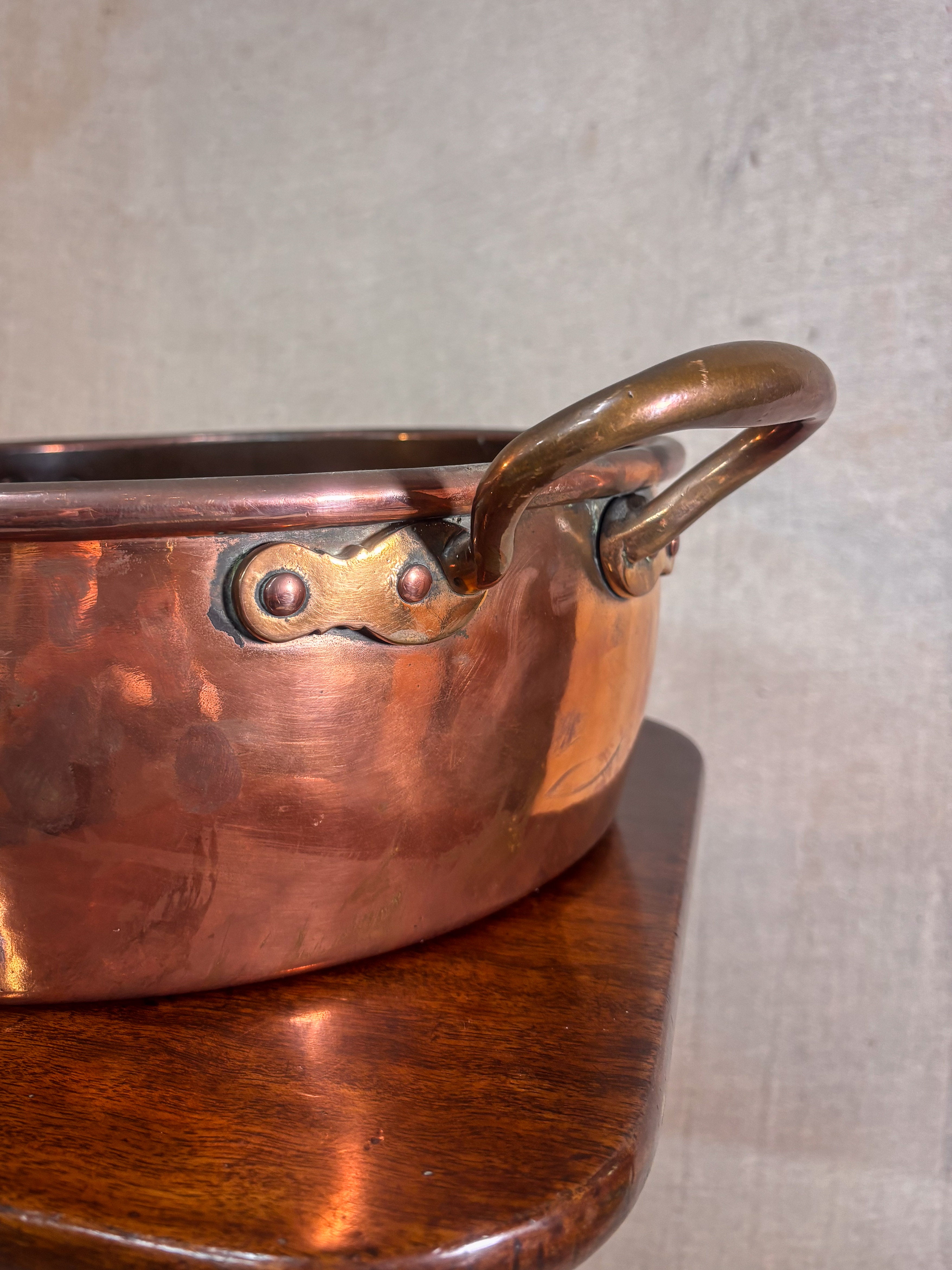 Copper pot with a handle on a wooden surface