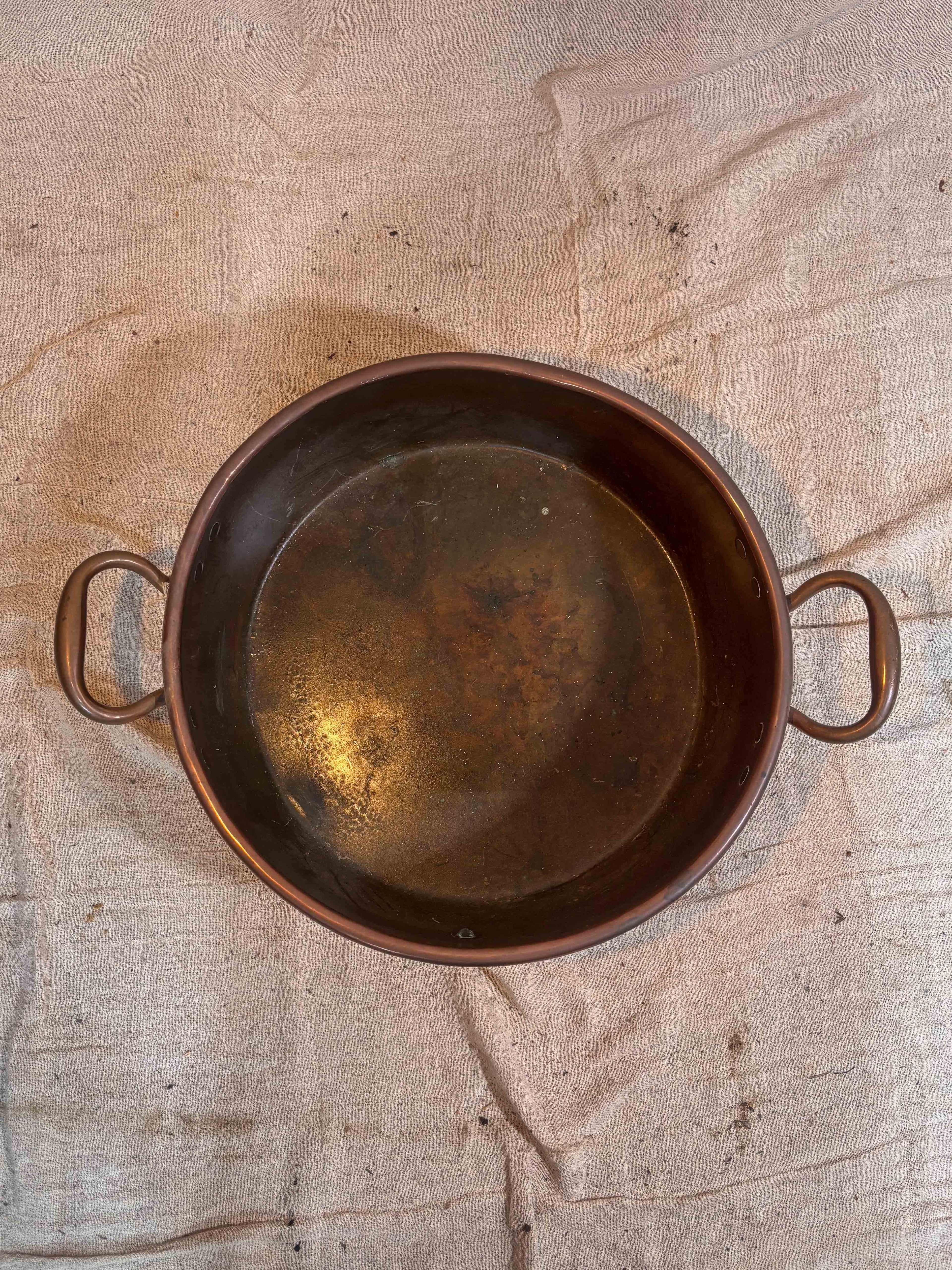 copper pot on a textured beige surface