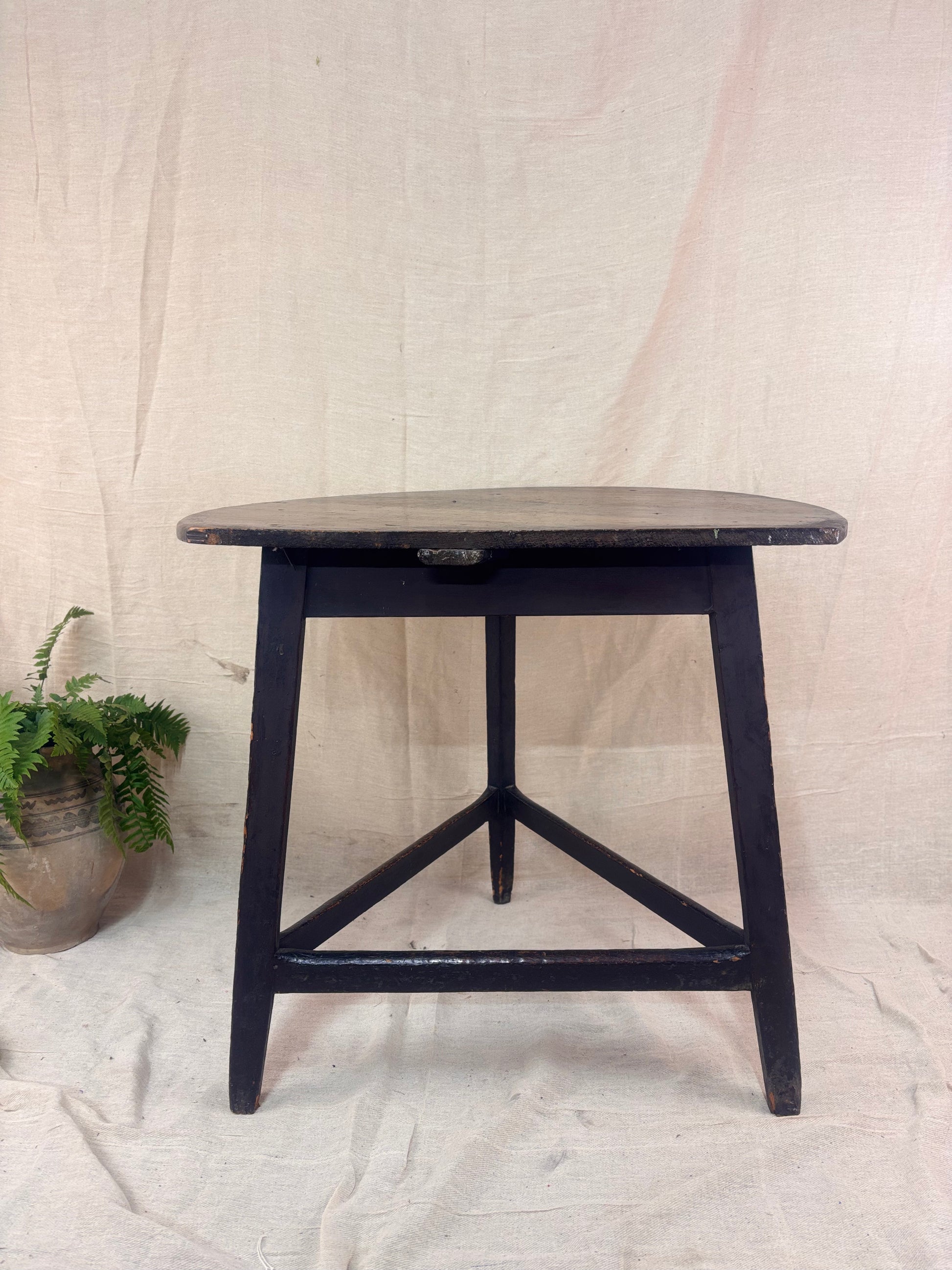 Black wooden side table against a plain background