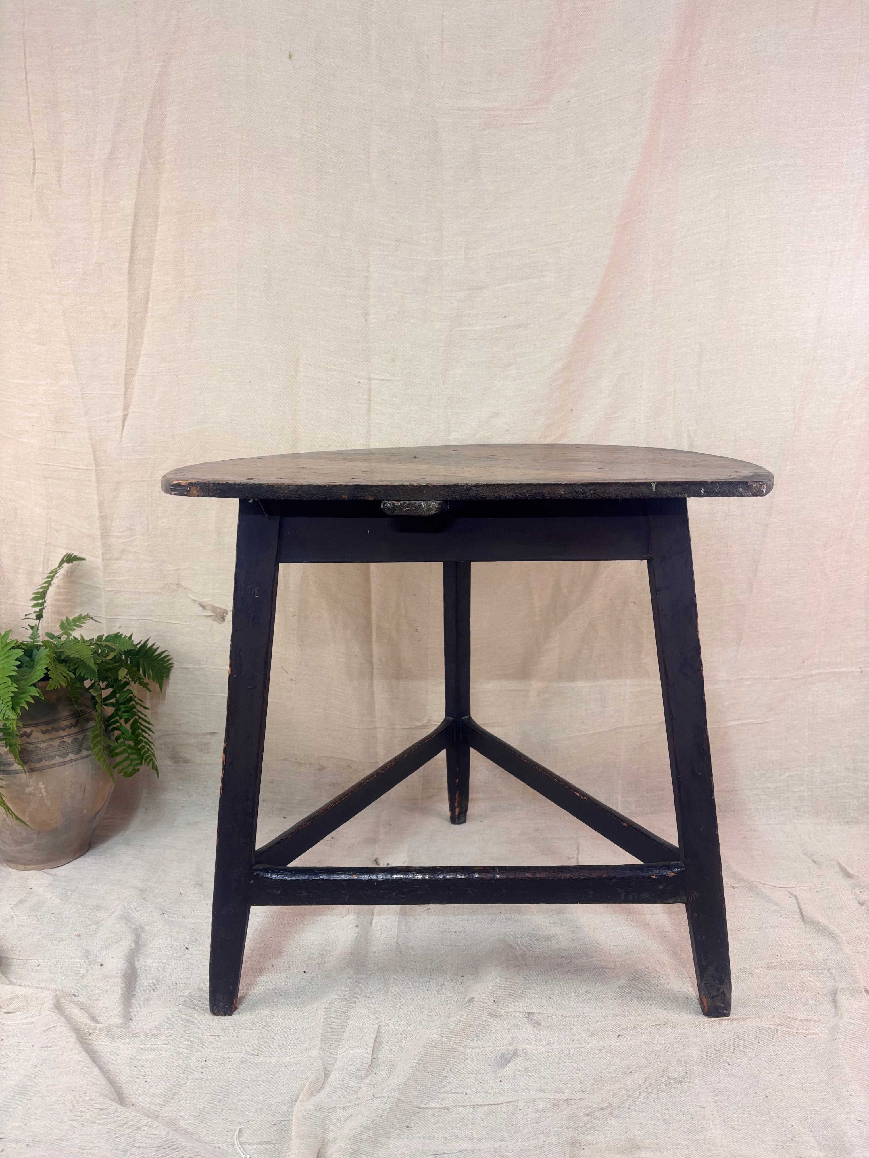 Black wooden side table against a plain background