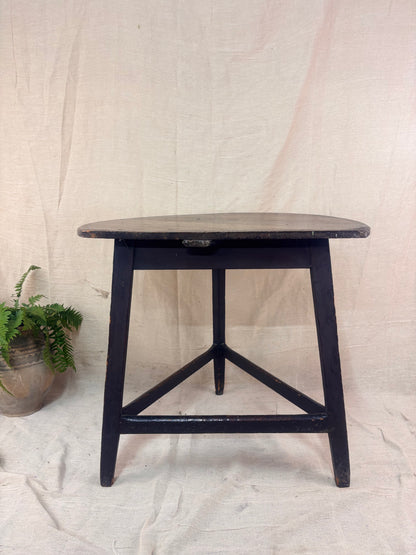 Black wooden side table against a plain background