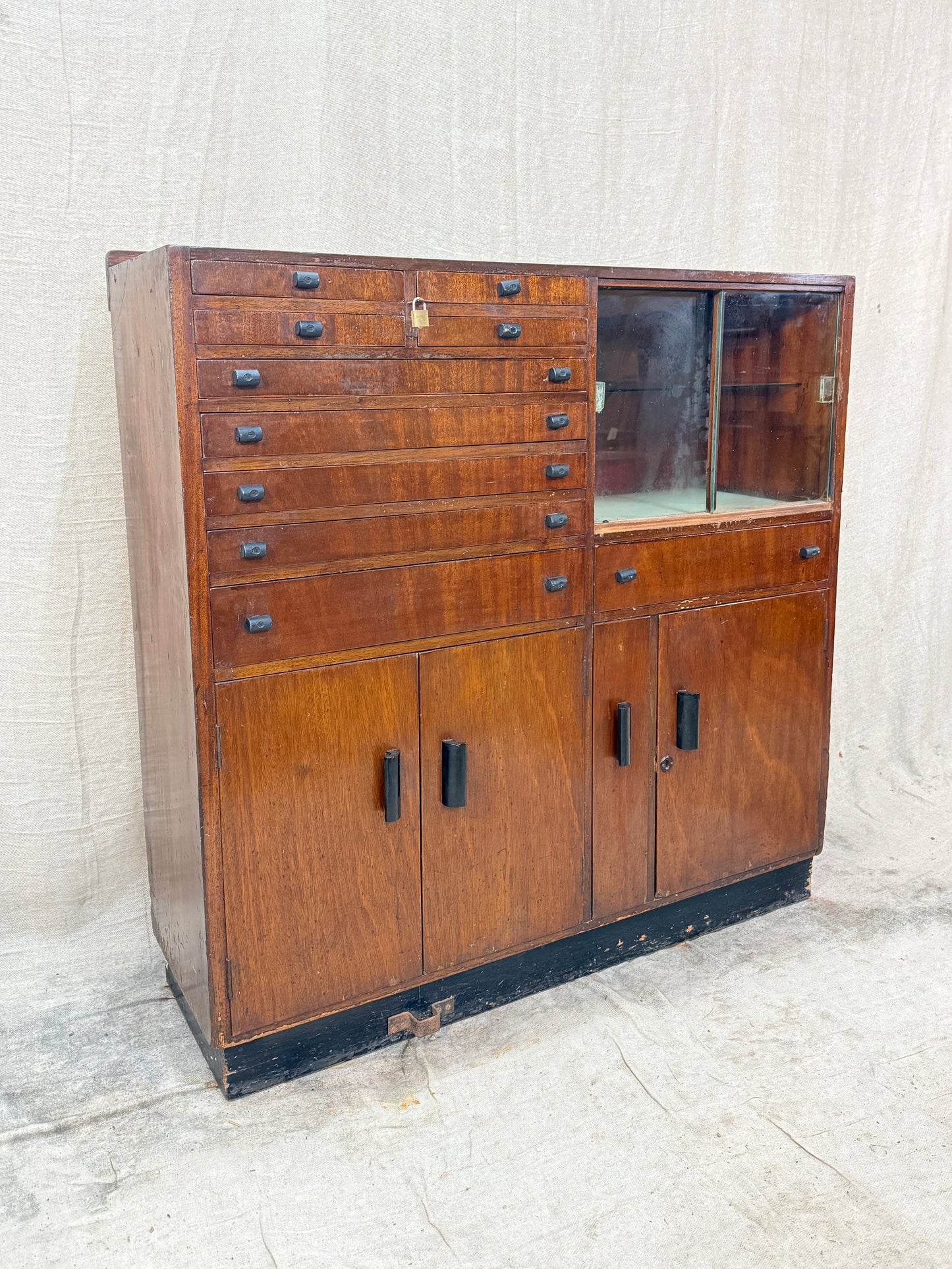 Vintage wooden cabinet with multiple drawers on a textured white background