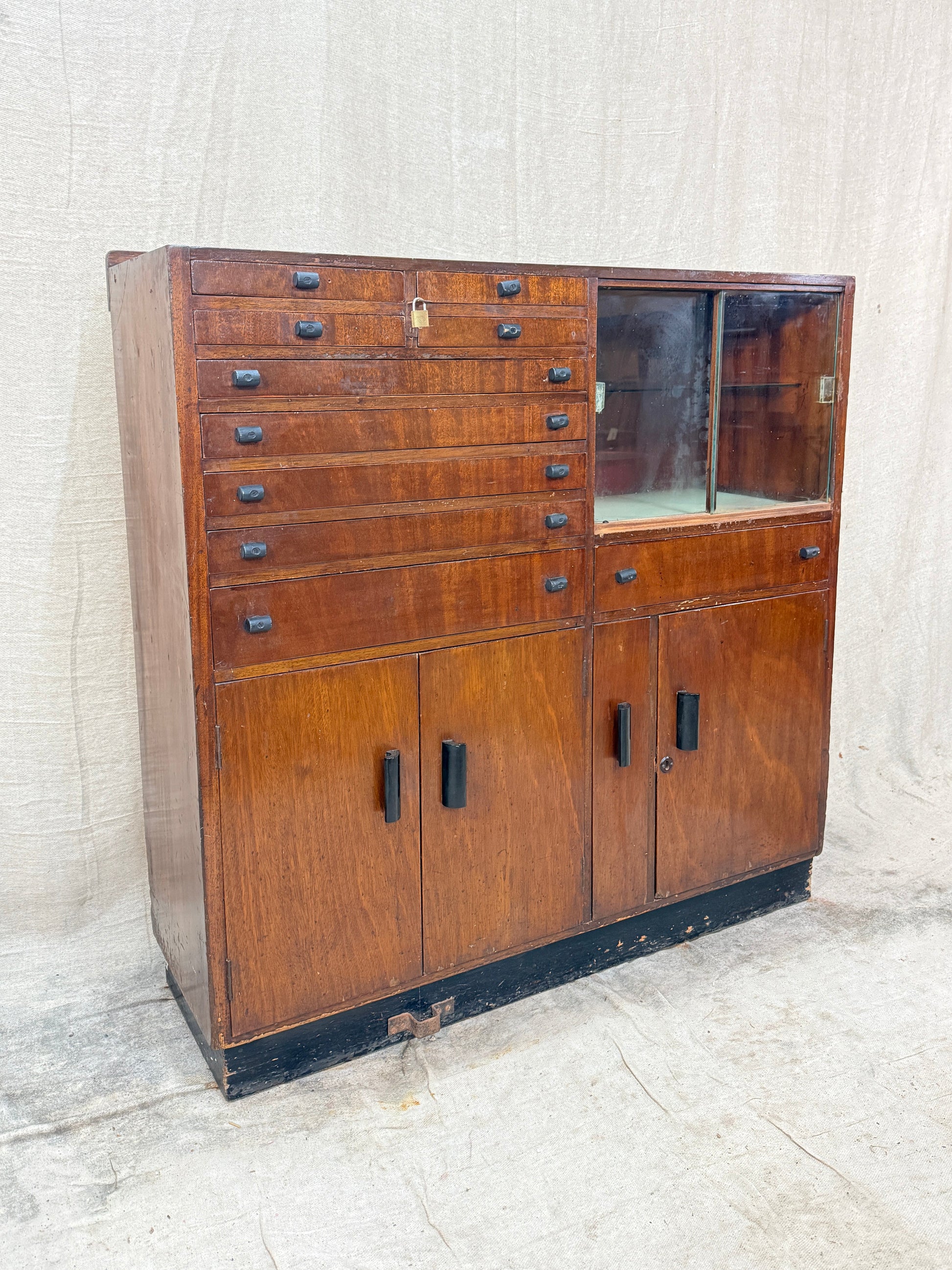 Vintage wooden cabinet with multiple drawers on a textured white background