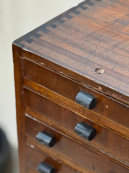 Close-up of an old wooden drawer with metal knobs on a plain background