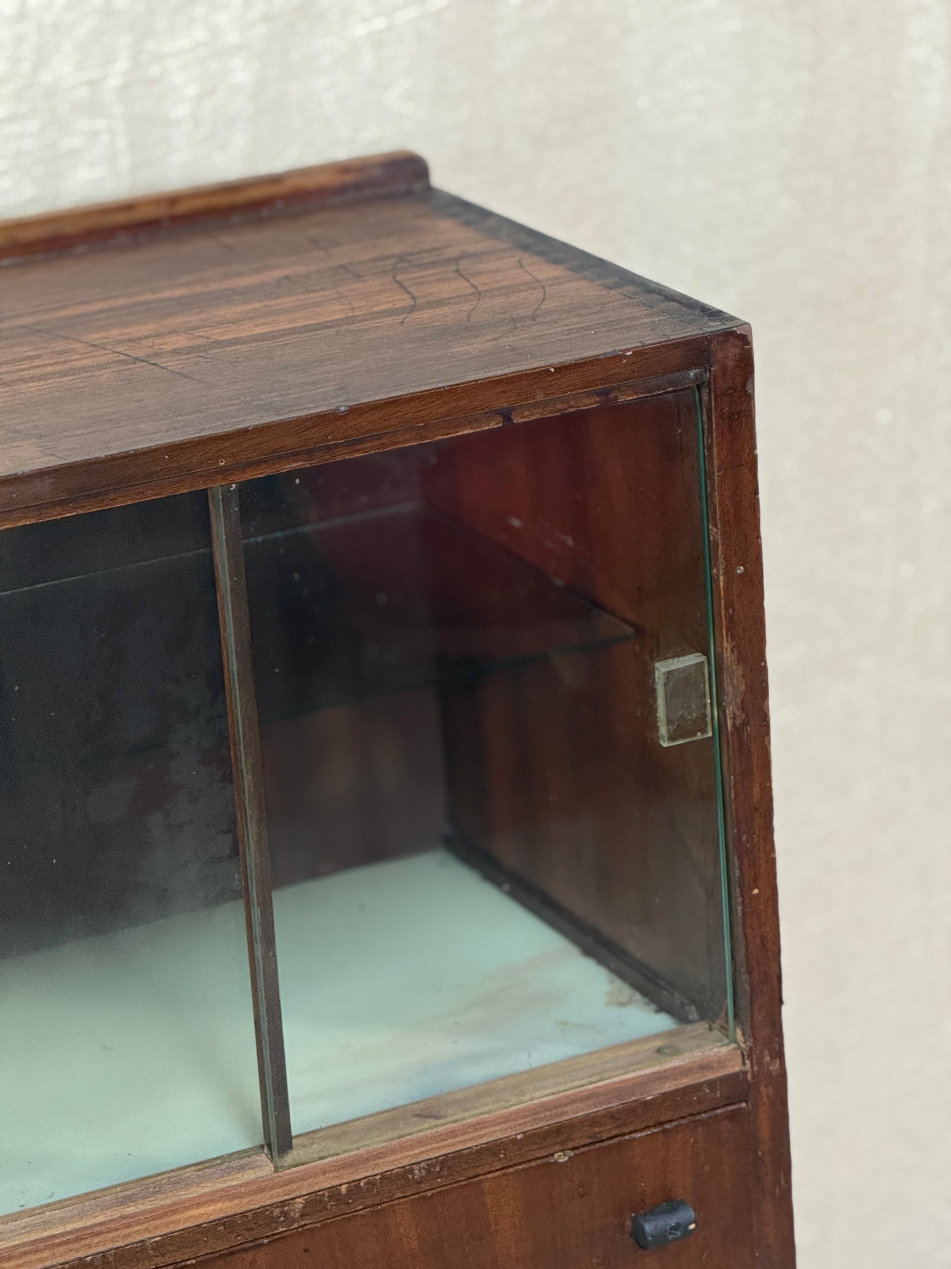 Wooden display cabinet with glass front on a white background