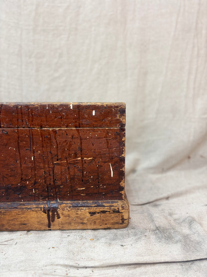 Vintage wooden box with a textured surface on a light fabric background
