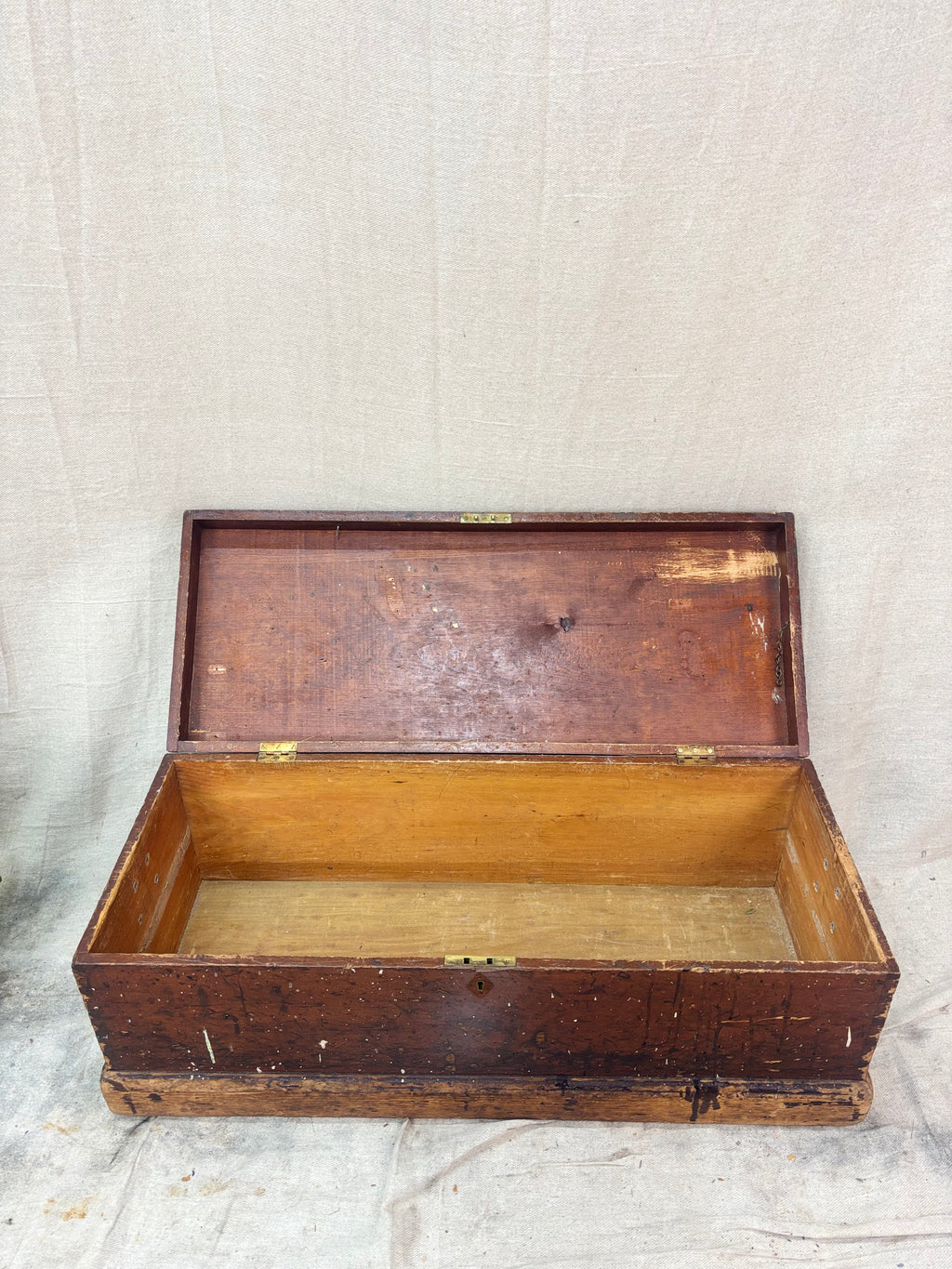 Wooden trunk with a hinged lid on a textured surface