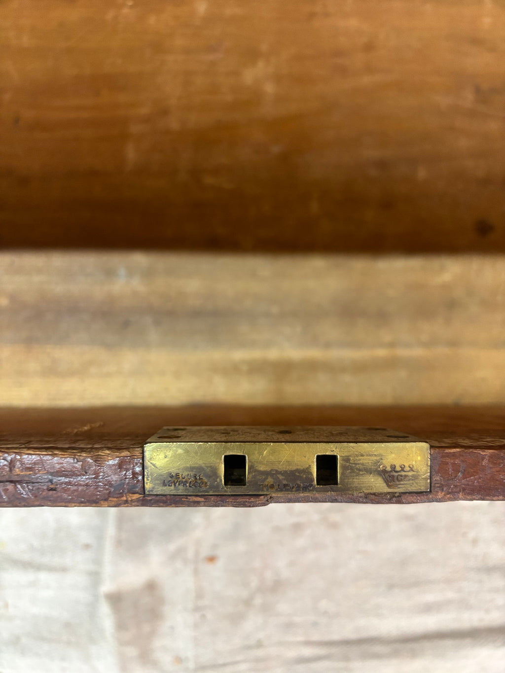 Close-up of a wooden object with a brass lock mechanism.