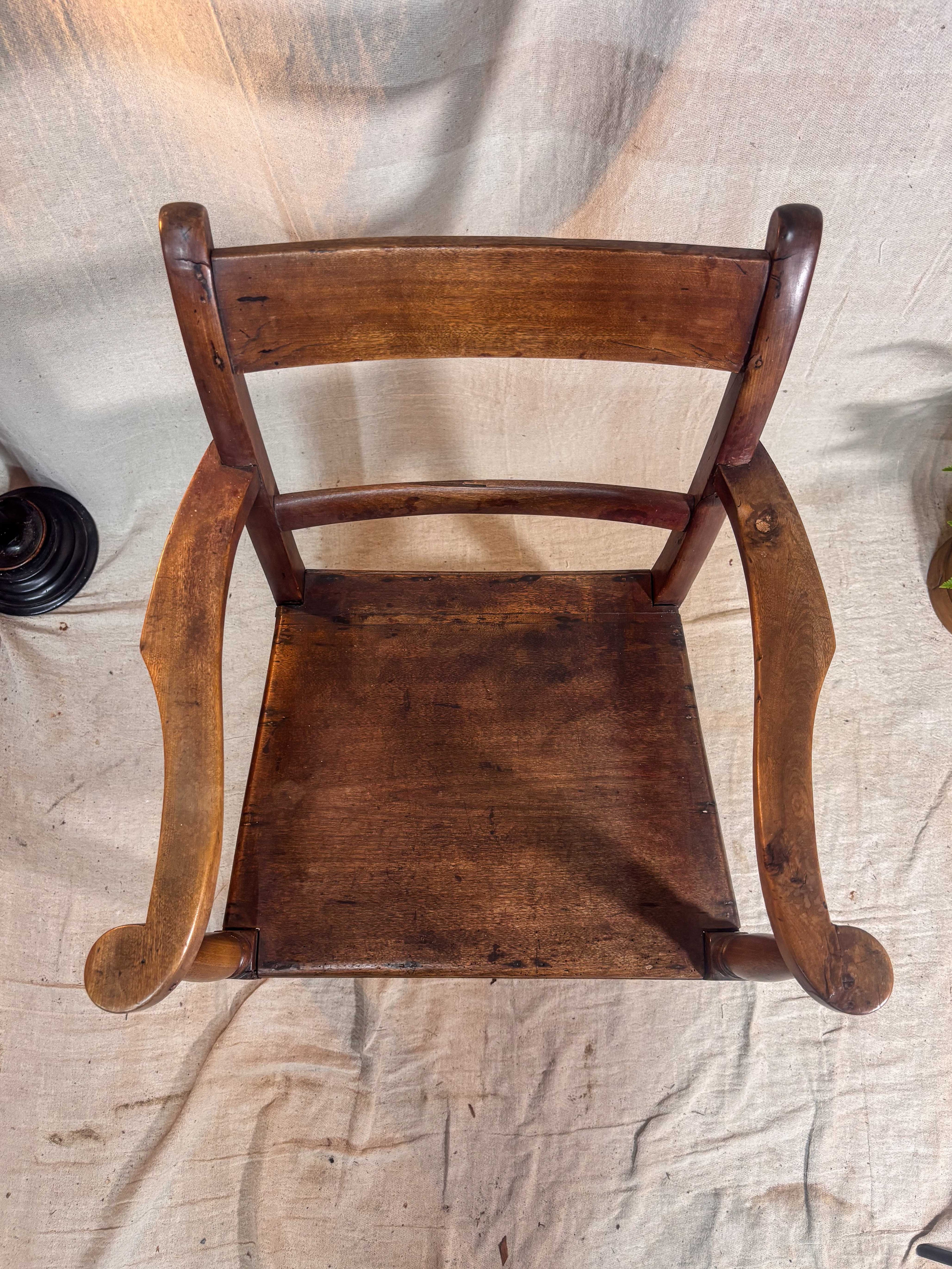Wooden chair with curved armrests on a textured fabric background