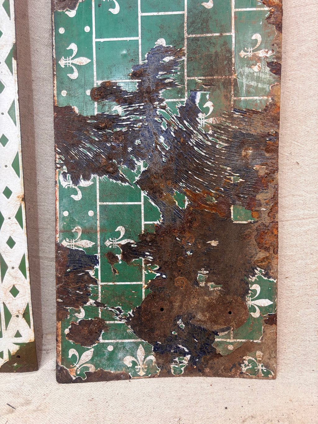 Rust-covered metal panel with decorative patterns on a textured surface