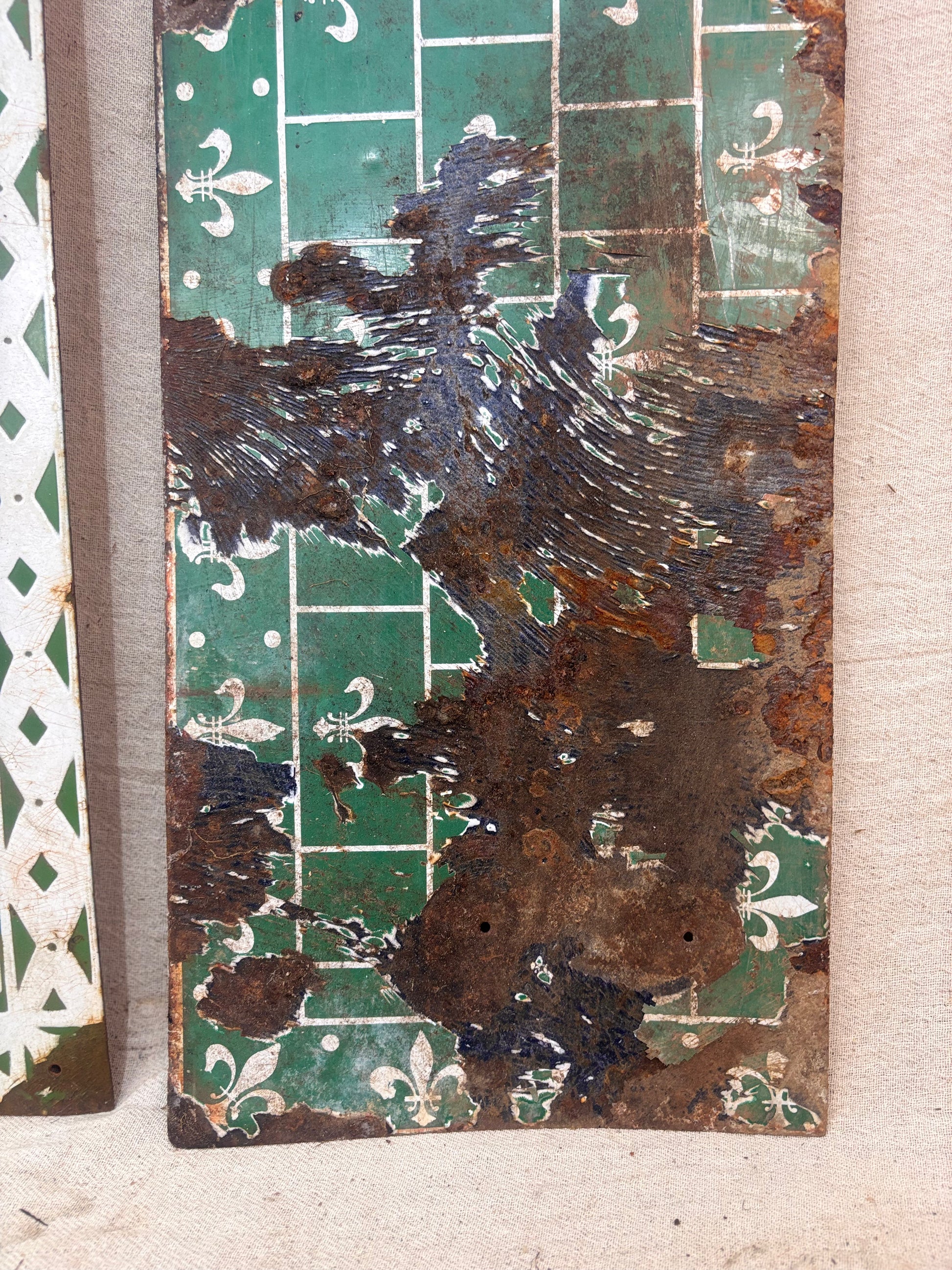 Rust-covered metal panel with decorative patterns on a textured surface