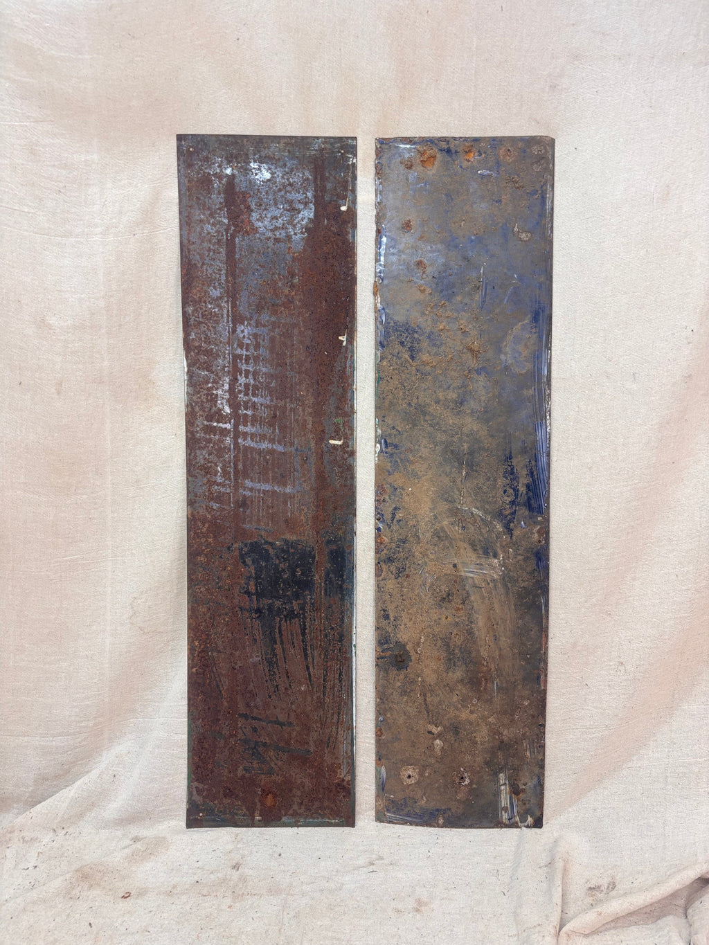 Two rusted metal panels on a textured beige background