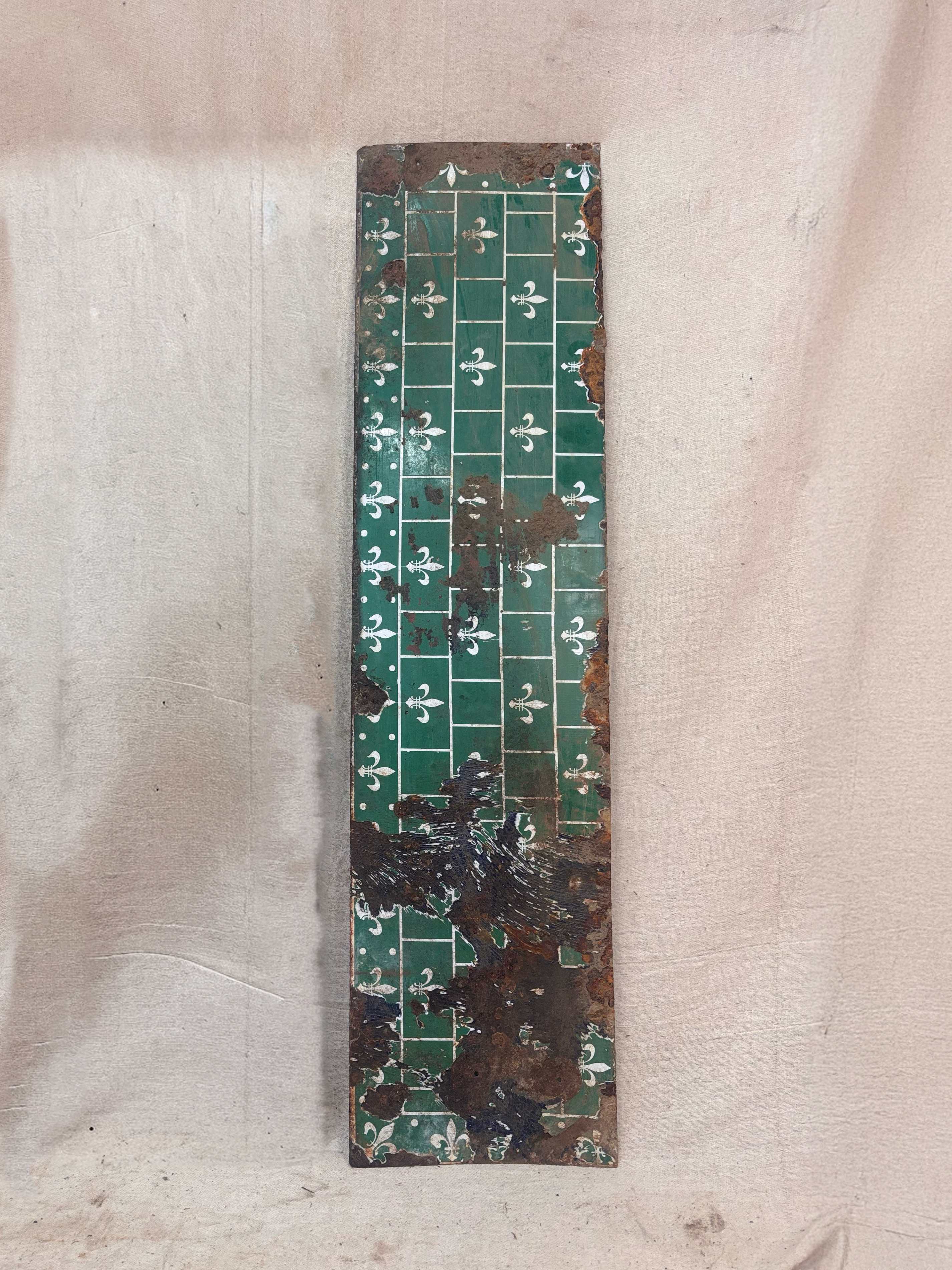 Rust-covered metal panel on a beige fabric background