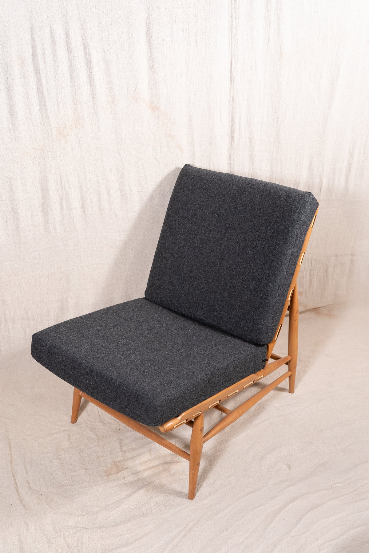 Mid-century modern Ercol Floating lounge chair, model 427, with a solid elm and beech frame and dark grey upholstered cushions. 