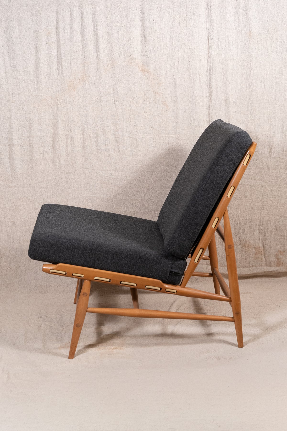 Mid-century modern Ercol Floating lounge chair, model 427, with a solid elm and beech frame and dark grey upholstered cushions. 