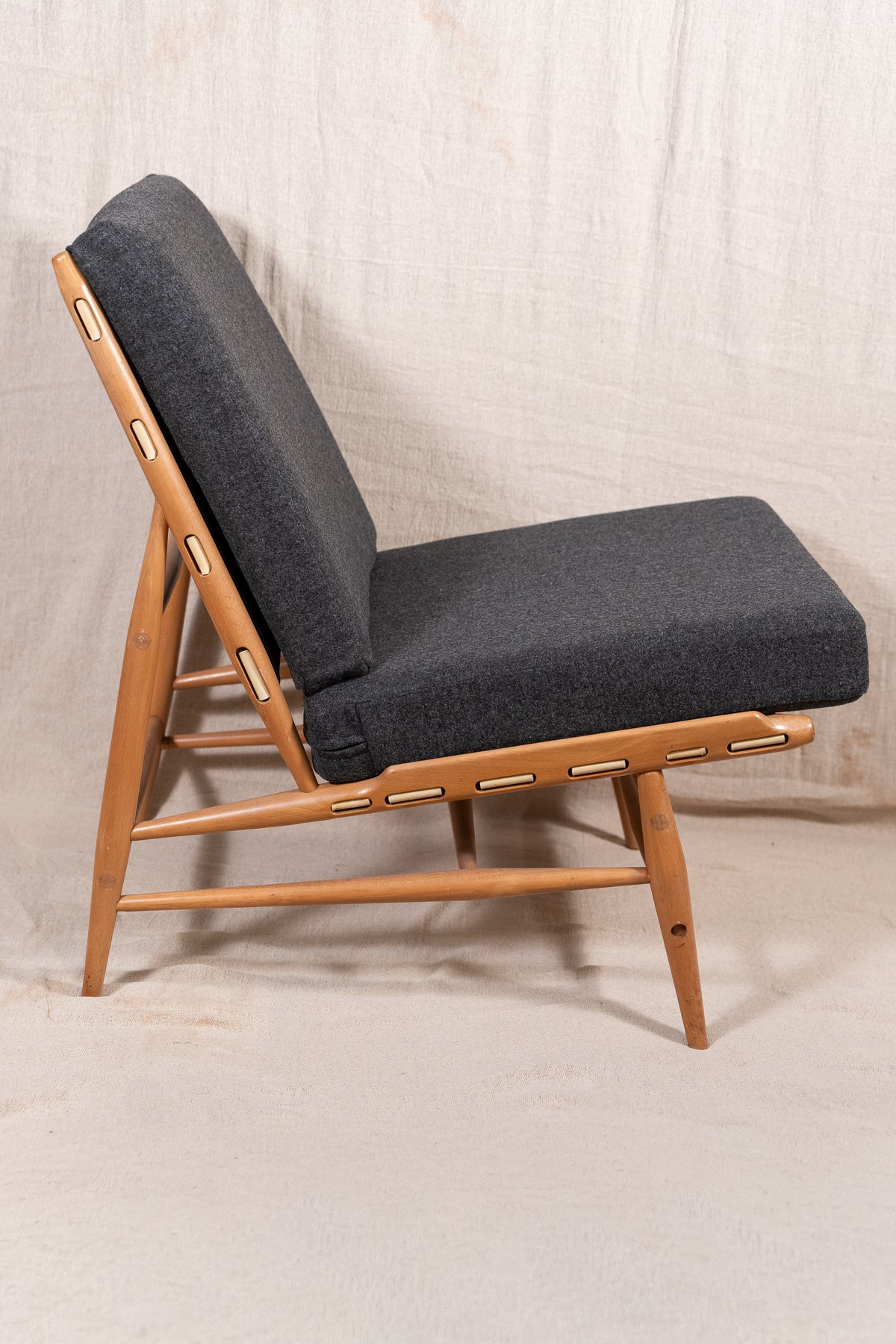 Mid-century modern Ercol Floating lounge chair, model 427, with a solid elm and beech frame and dark grey upholstered cushions. 