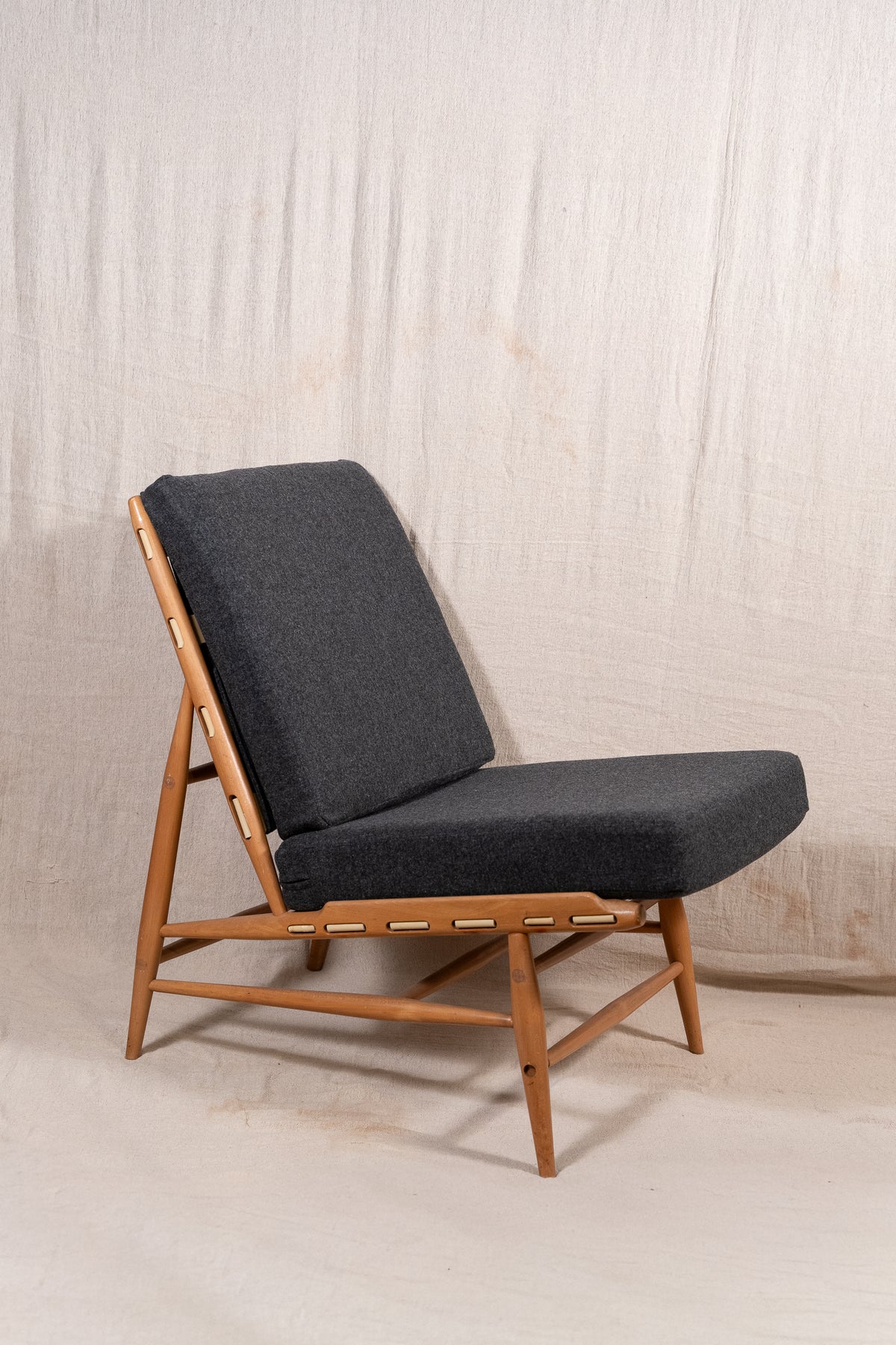 Mid-century modern Ercol Floating lounge chair, model 427, with a solid elm and beech frame and dark grey upholstered cushions. Good condition for age and use.