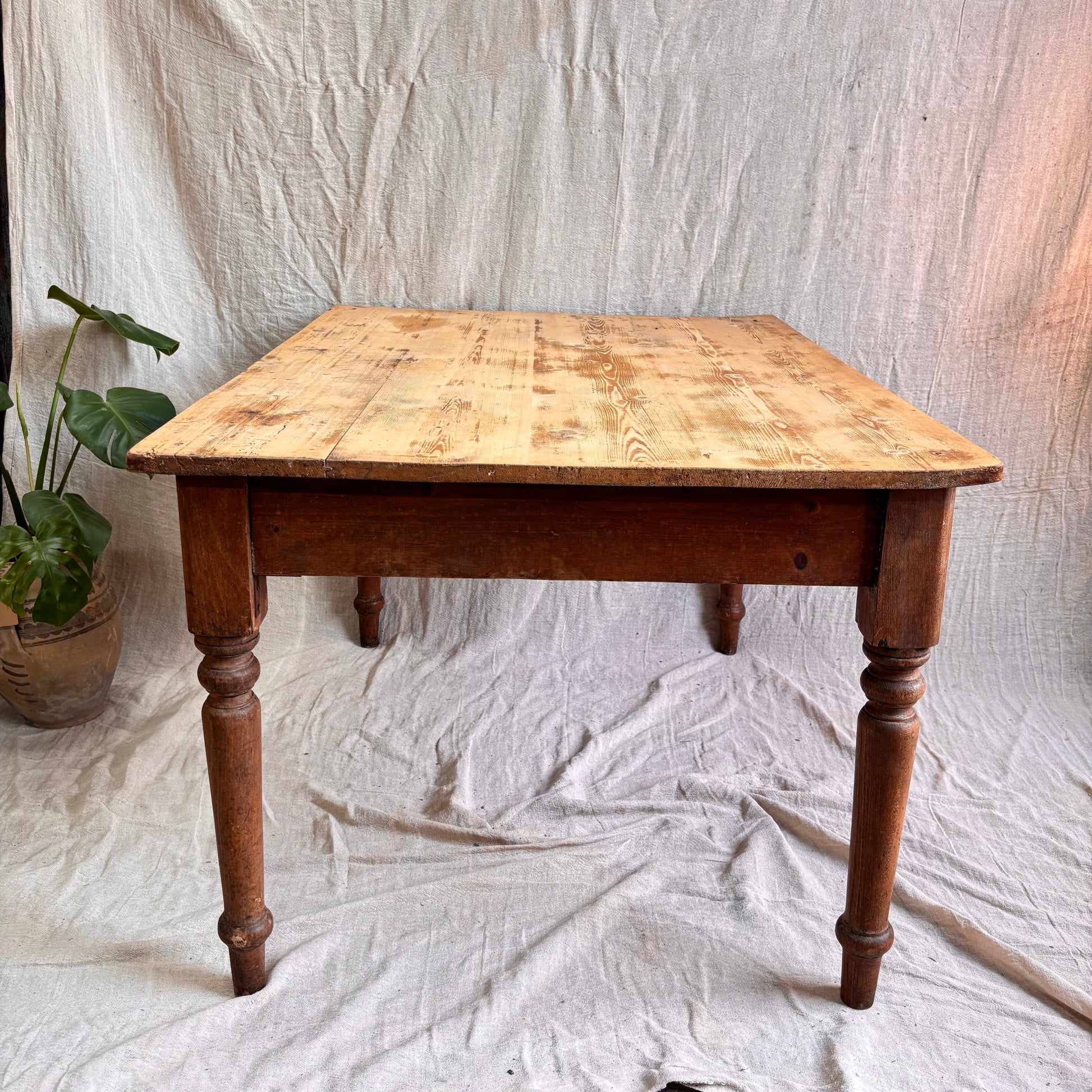 Wooden table with a checkered surface on a white fabric background