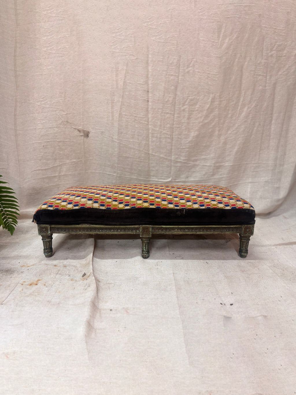 Decorative bench with a patterned cushion on a plain background