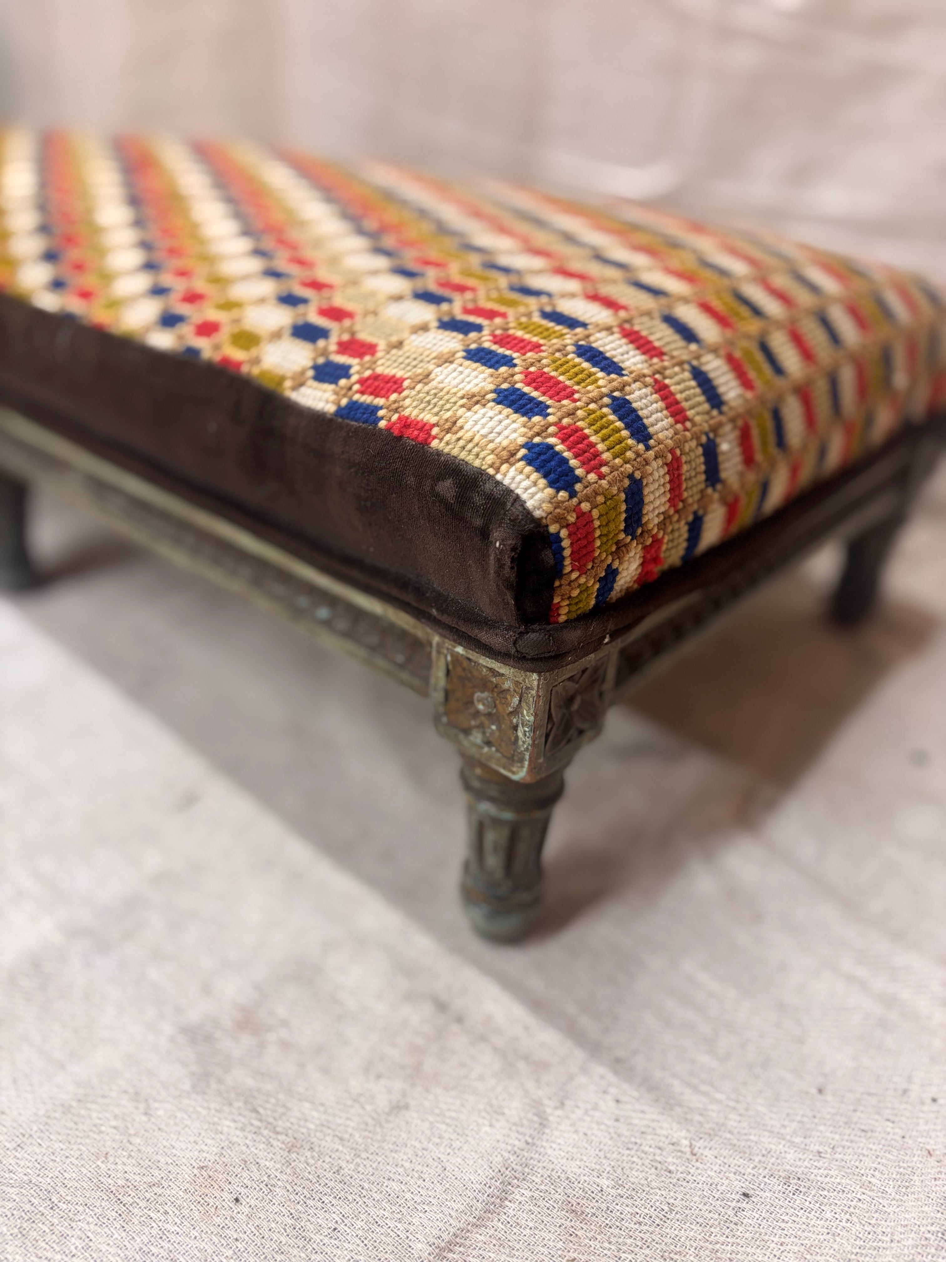 Decorative bench with a multicolored patterned cushion on a neutral background