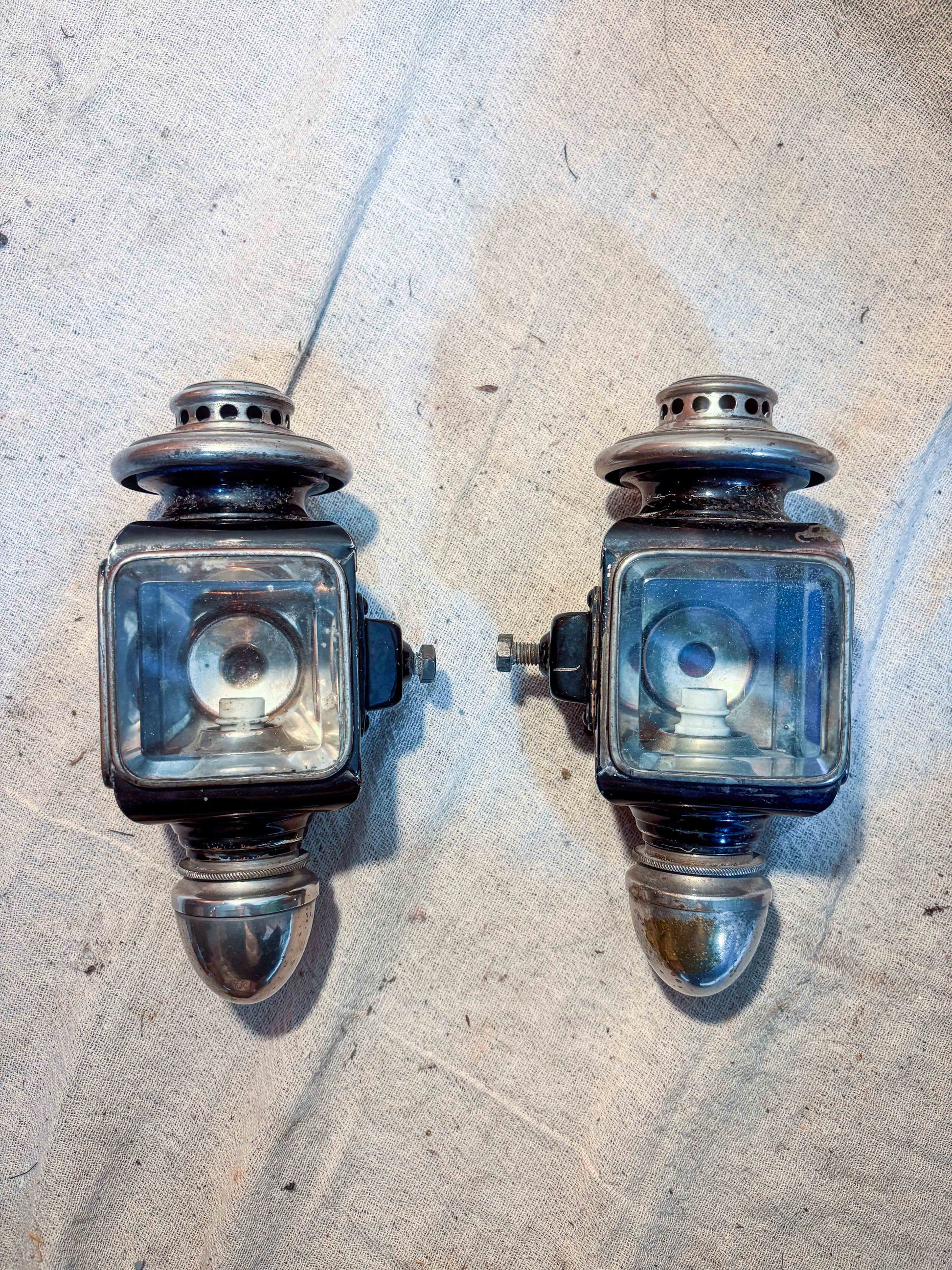two small carriage lamps on cloth background