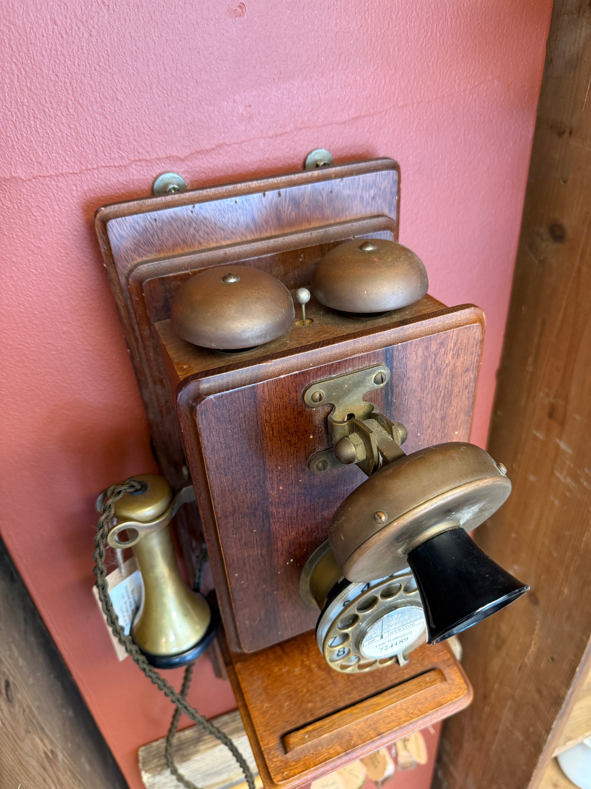Vintage wooden telephone with metal components on a wooden surface