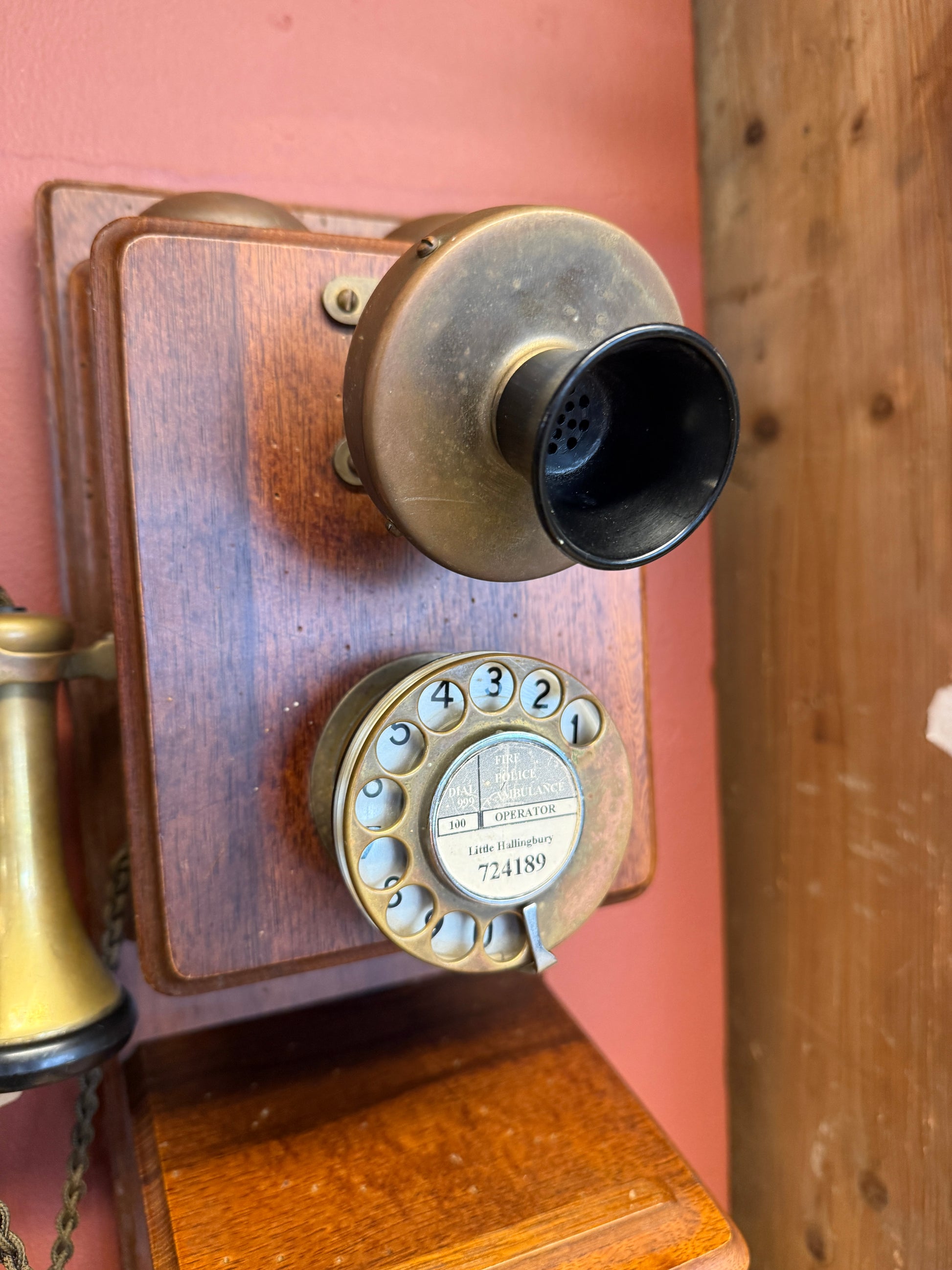 Vintage rotary phone on a wooden surface with a wooden panel background