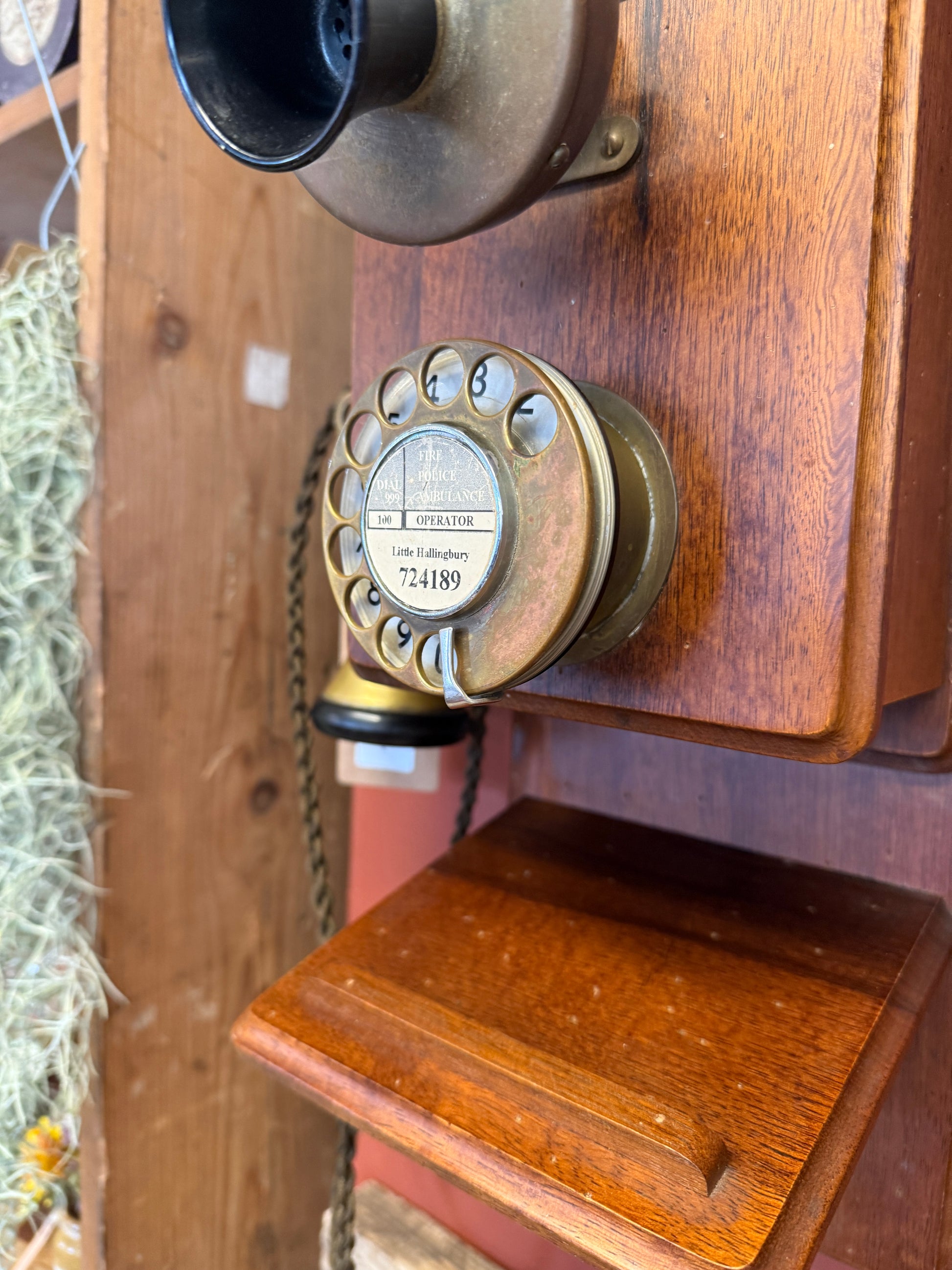 Vintage wooden telephone with brass dial on a wooden surface