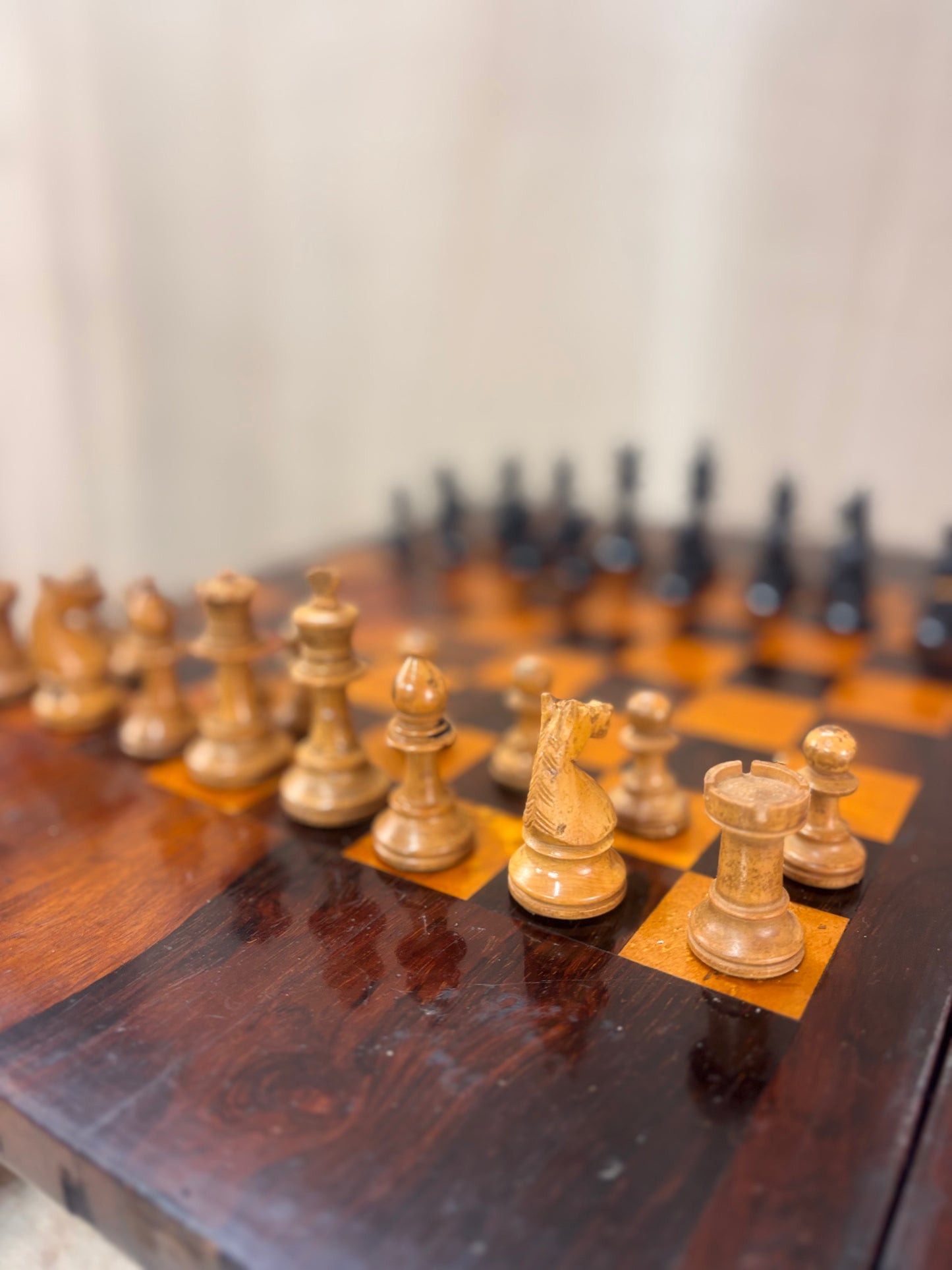 Wooden chess pieces on a chessboard with a blurred background