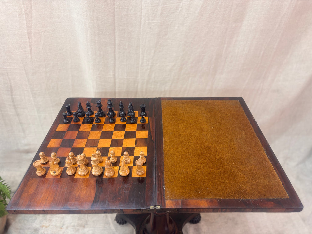Antique rosewood fold-over games table with inlaid chessboard, baize card surface, turned pedestal base, shown open with chess pieces.