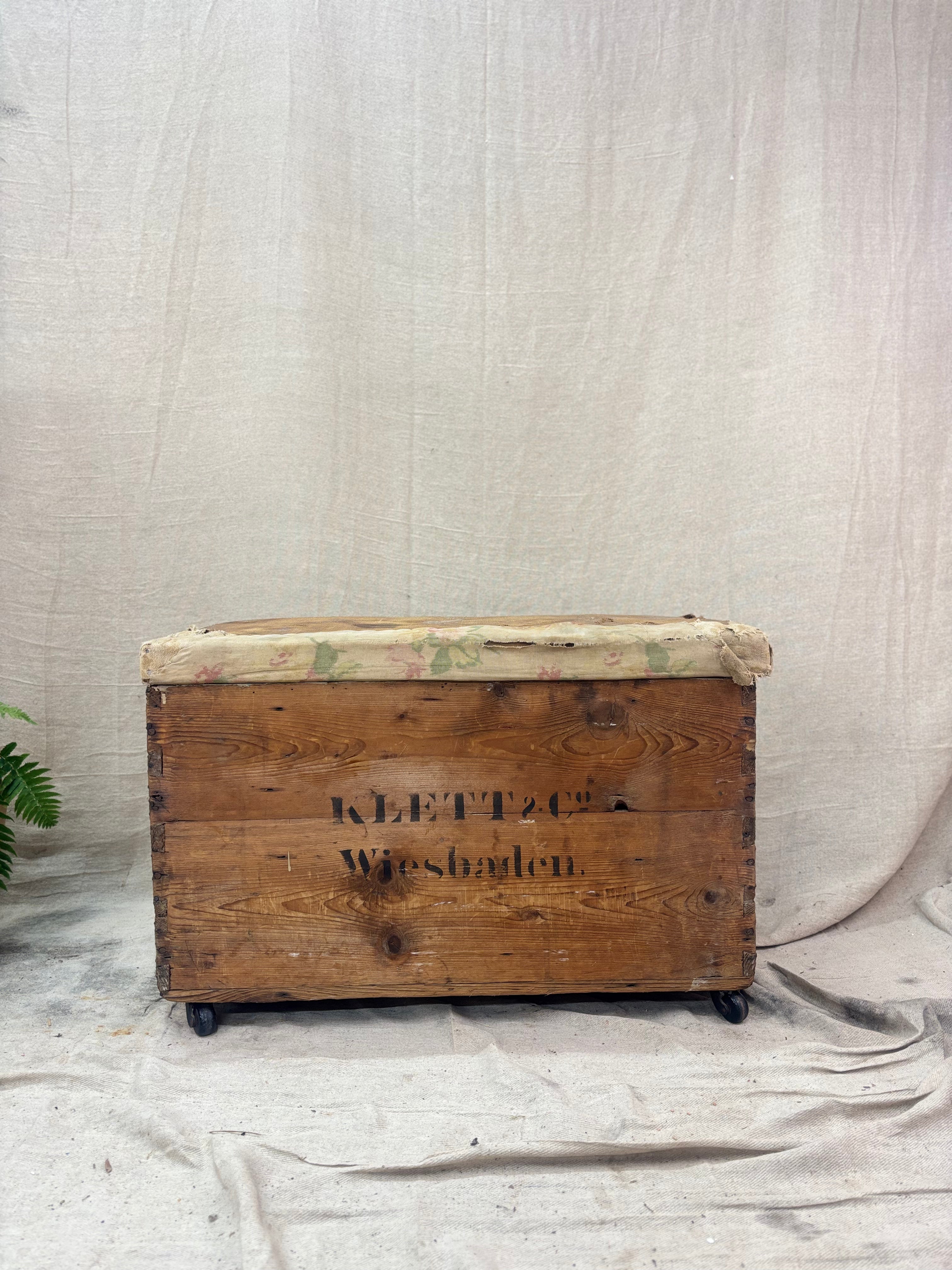 Wooden chest with 'Klett & Co' branding on a textured white background