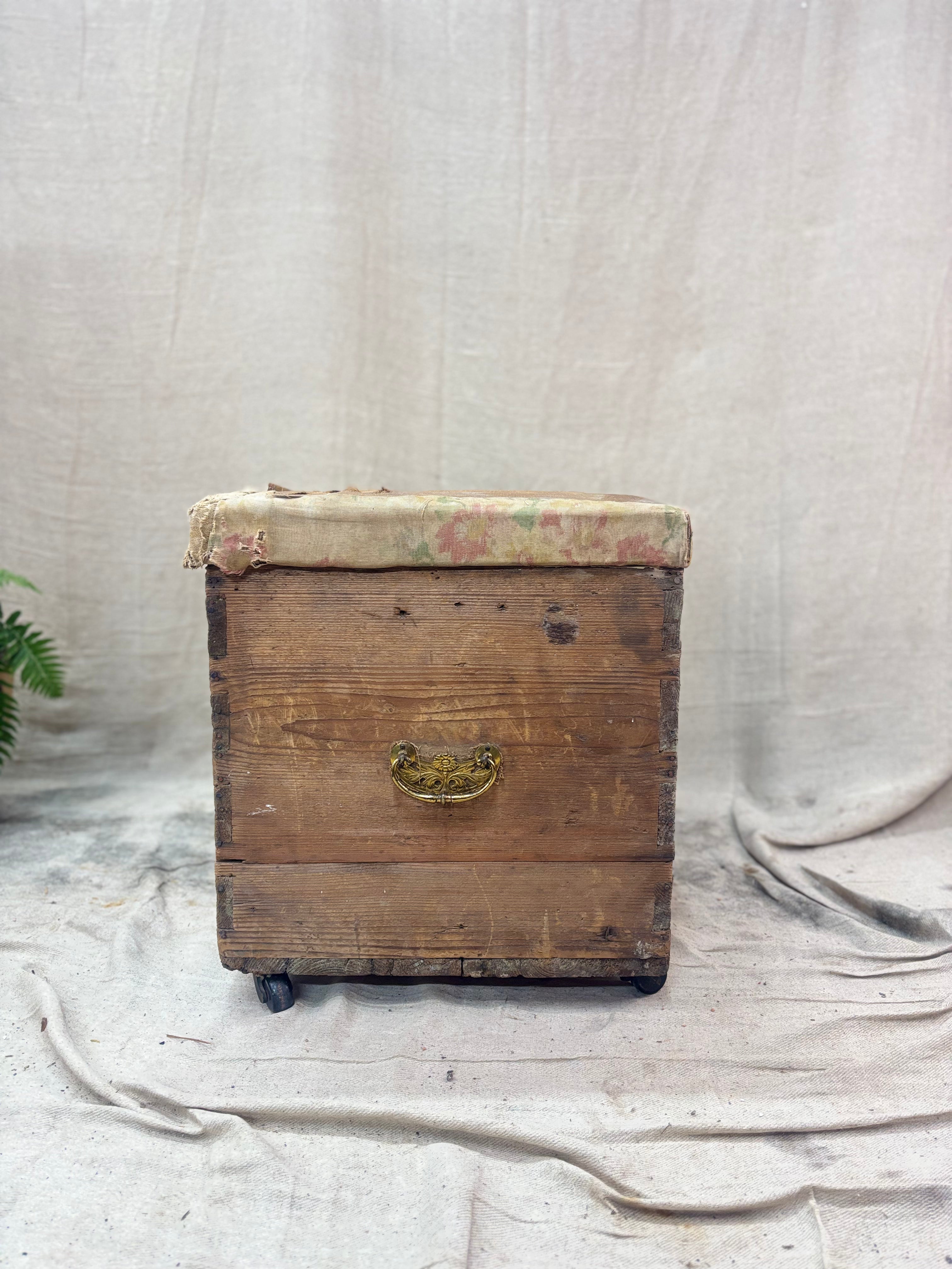Vintage wooden trunk with floral patterned lid on a textured surface