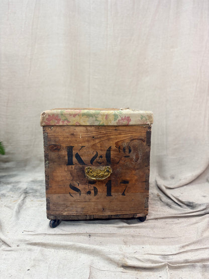 Vintage wooden trunk with floral top on a draped fabric background