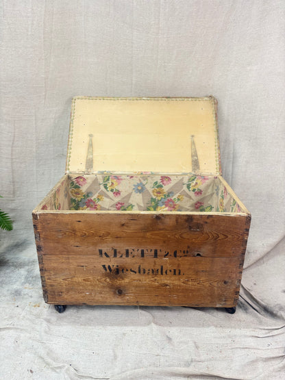 Wooden storage box with floral interior on a neutral background