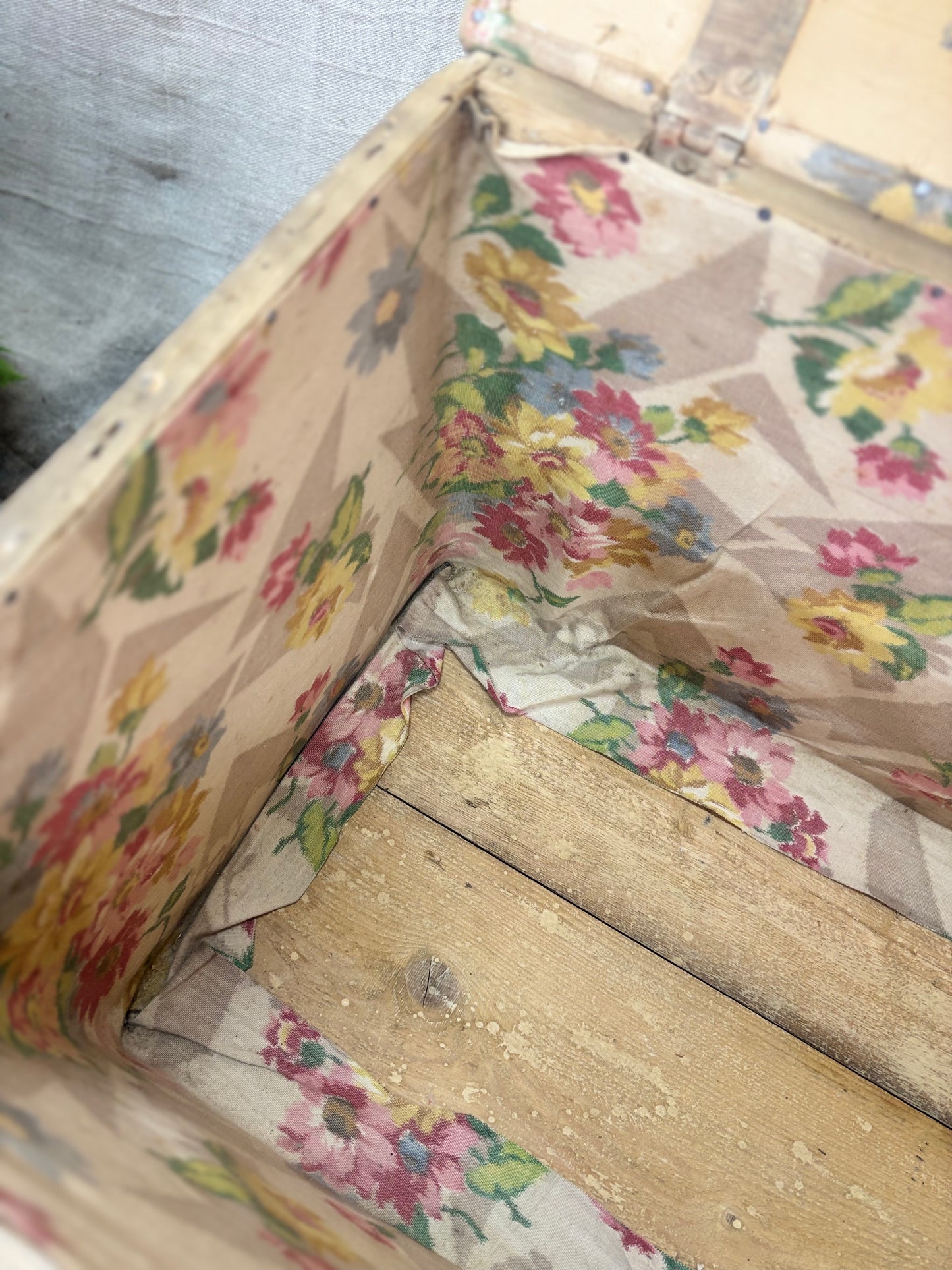 Floral-patterned fabric lining an open wooden box.
