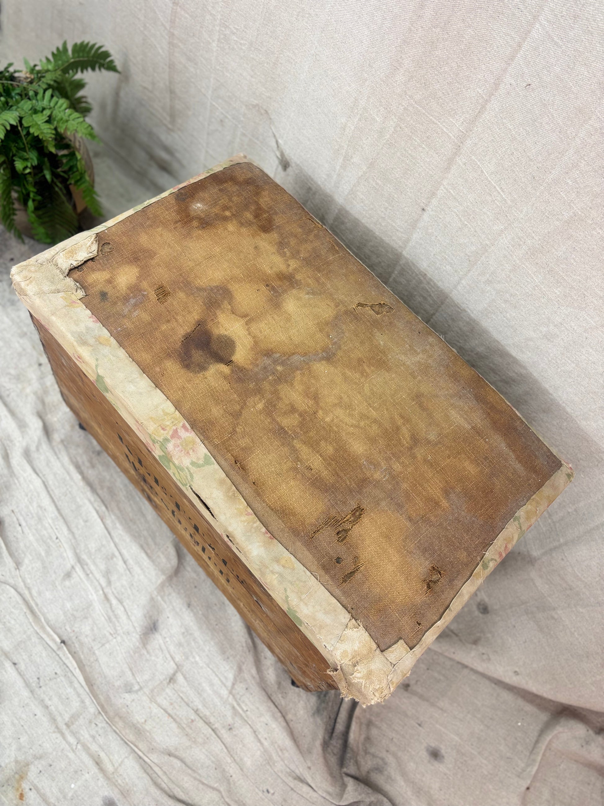 Vintage wooden box with a textured surface on a light fabric background