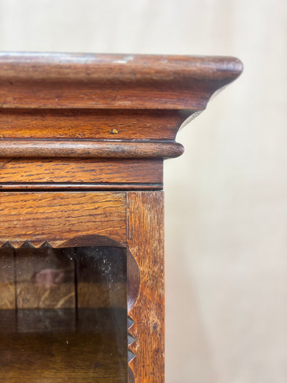 Close-up of a wooden cabinet with glass door on a white background
