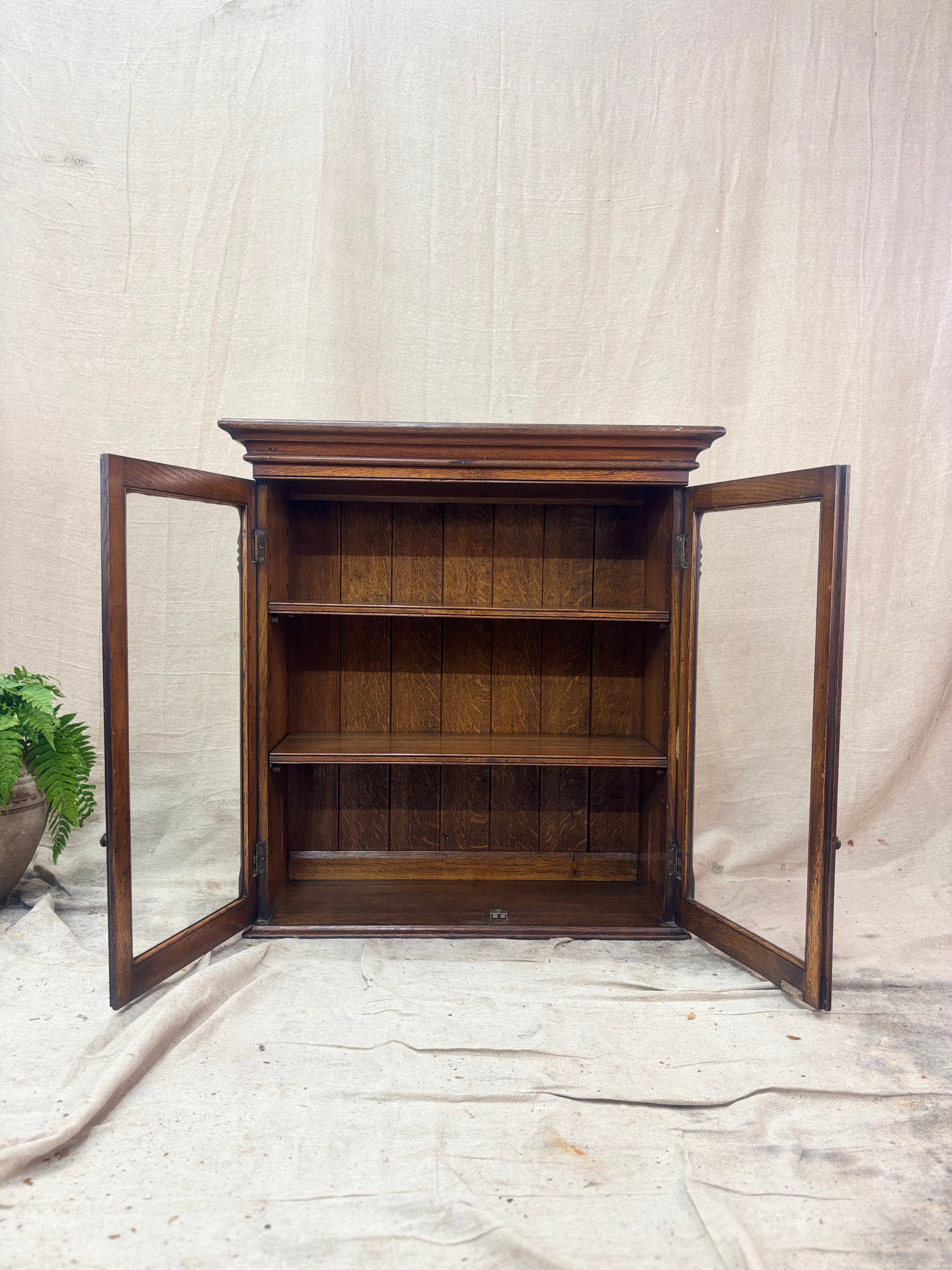 Wooden cabinet with open doors on a neutral background