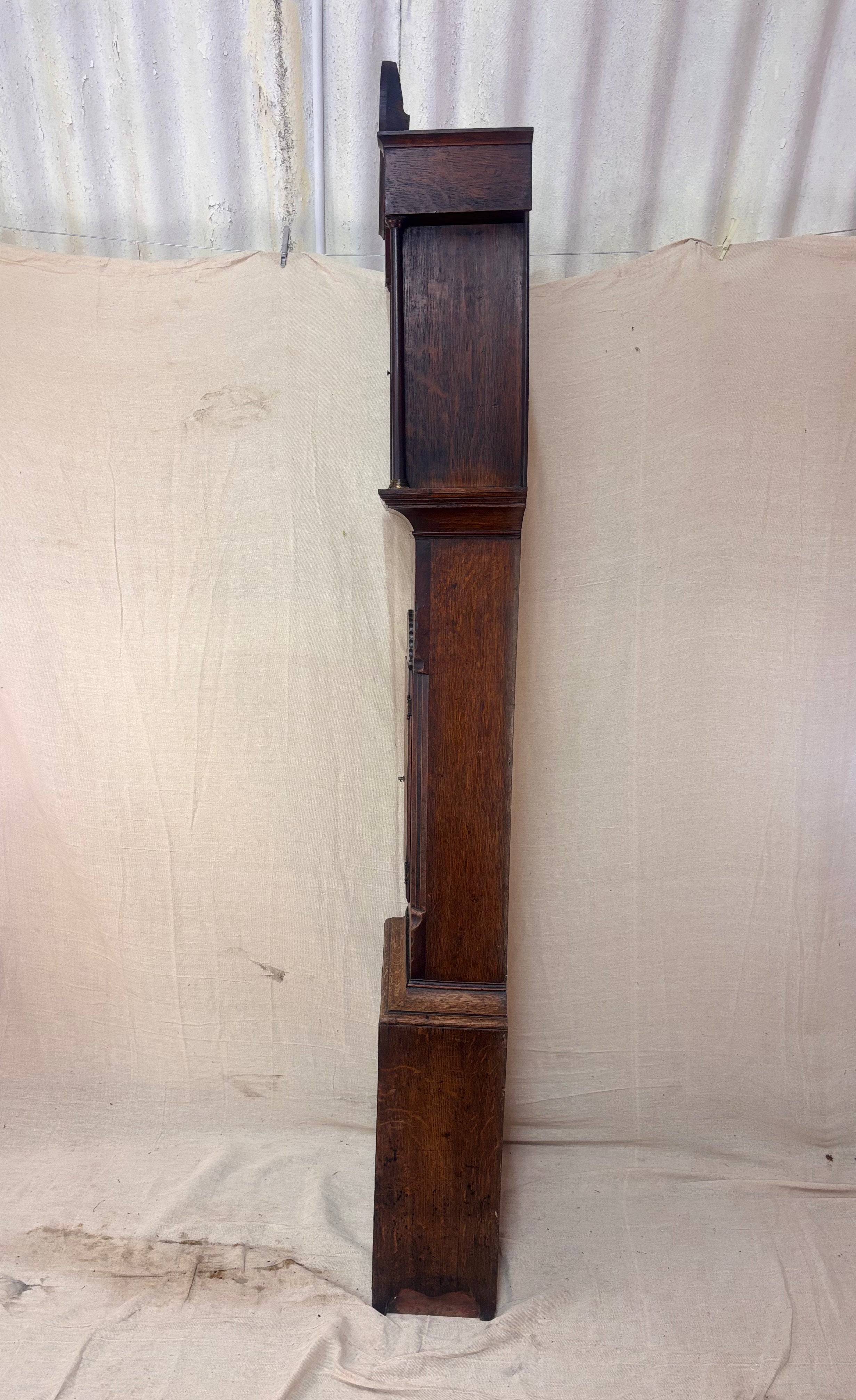 Side of a Grandfather clock against a cloth background