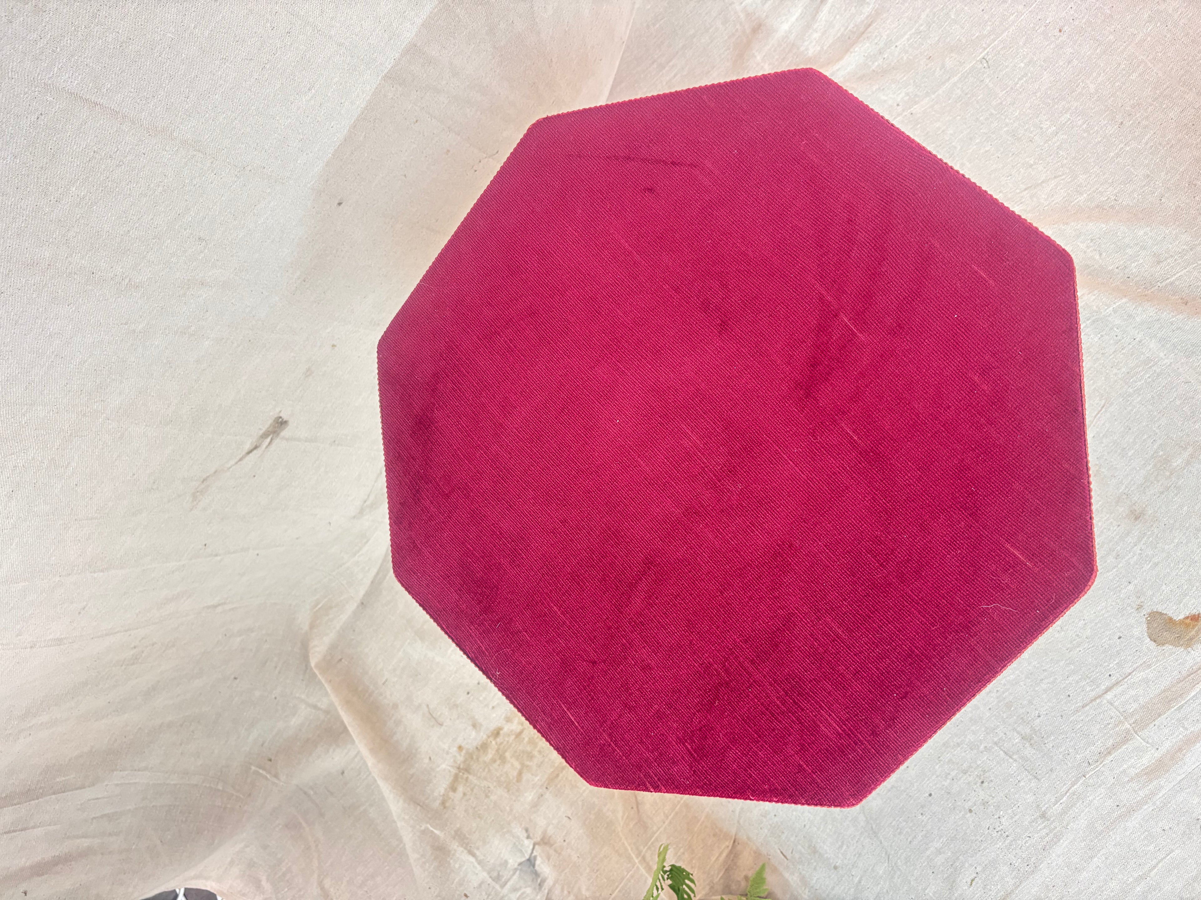 Antique Victorian ebonized bobbin-legged gypsy table with red velvet octagonal top and fringing, photographed against a cloth backdrop next to a plant