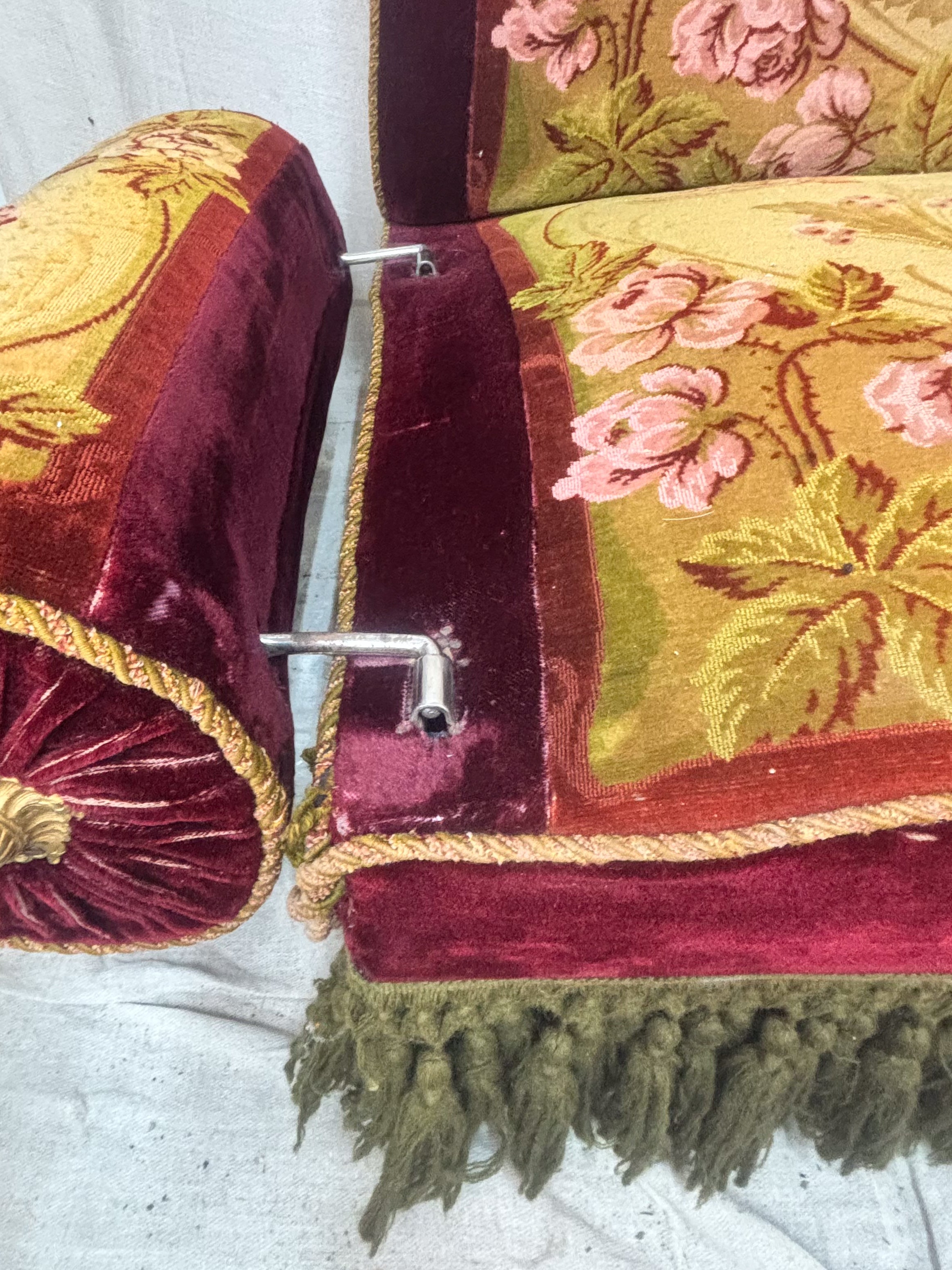 Decorative armchair with floral pattern and red velvet trim on a plain background