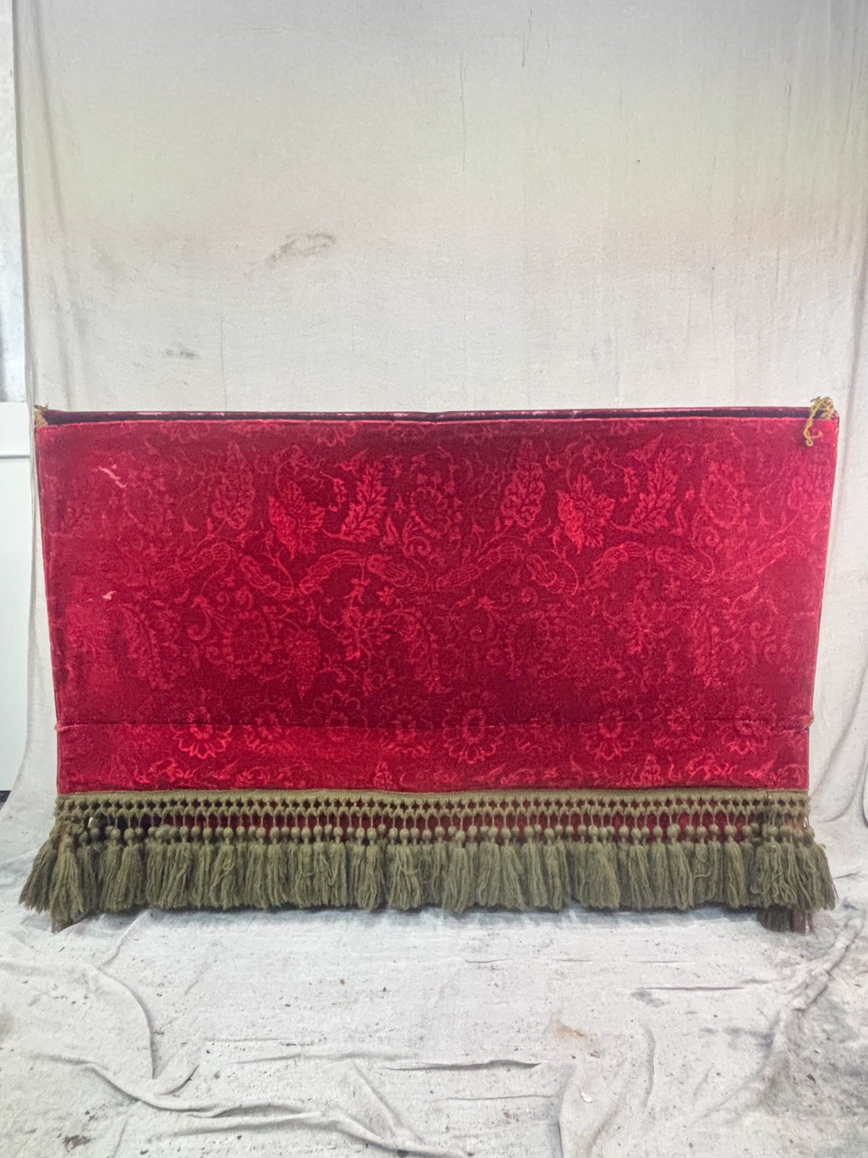 Red patterned sofa back with tassels on a white background