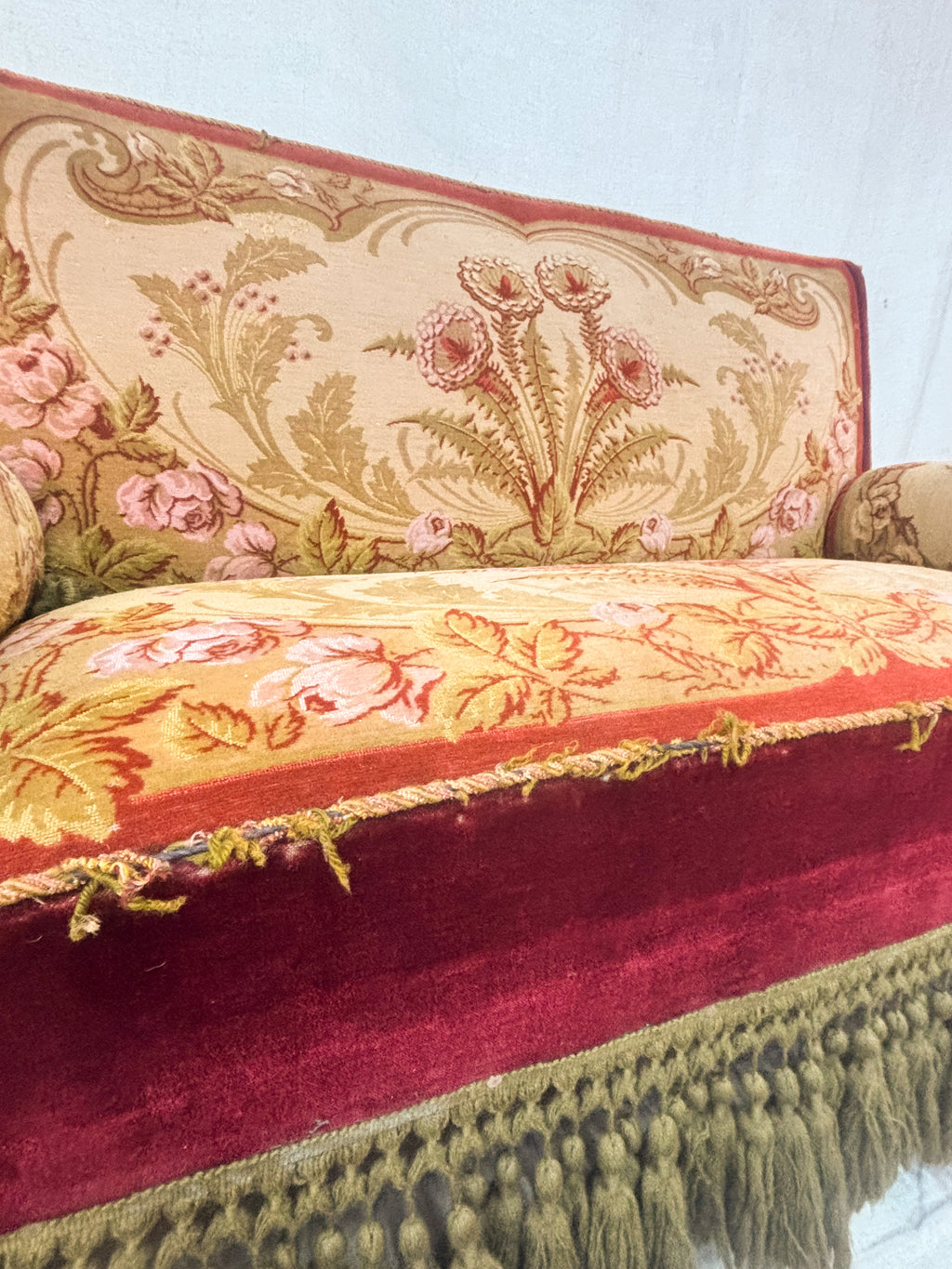 Decorative floral-patterned fabric with red, yellow, and pink colors on a white background