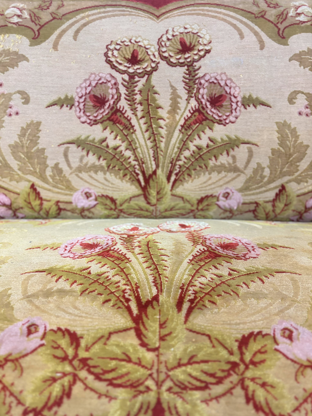 Close-up of floral patterned fabric with pink flowers and green leaves.