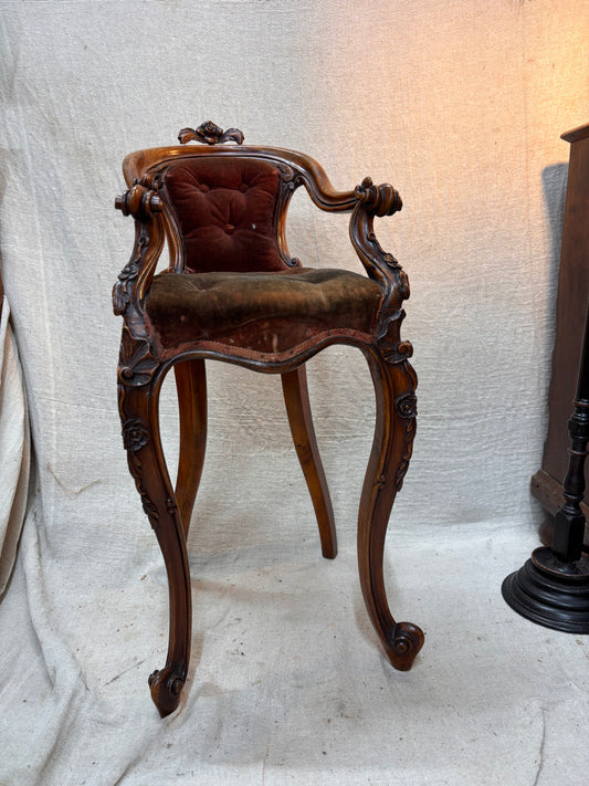 Victorian wooden chair with tufted cushion on a textured white background