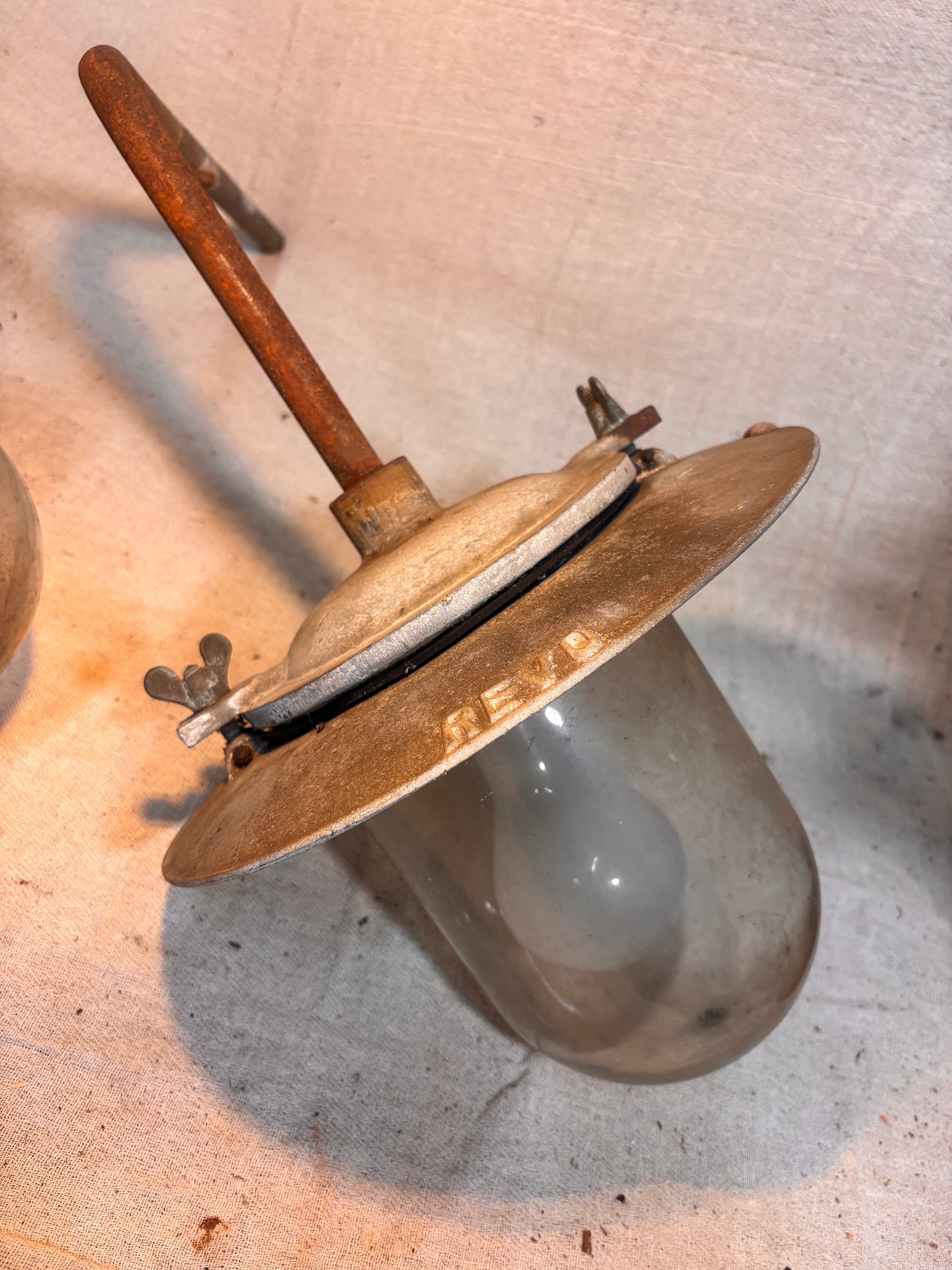 metal and glass industrial light fitting with the name REVO marked on top