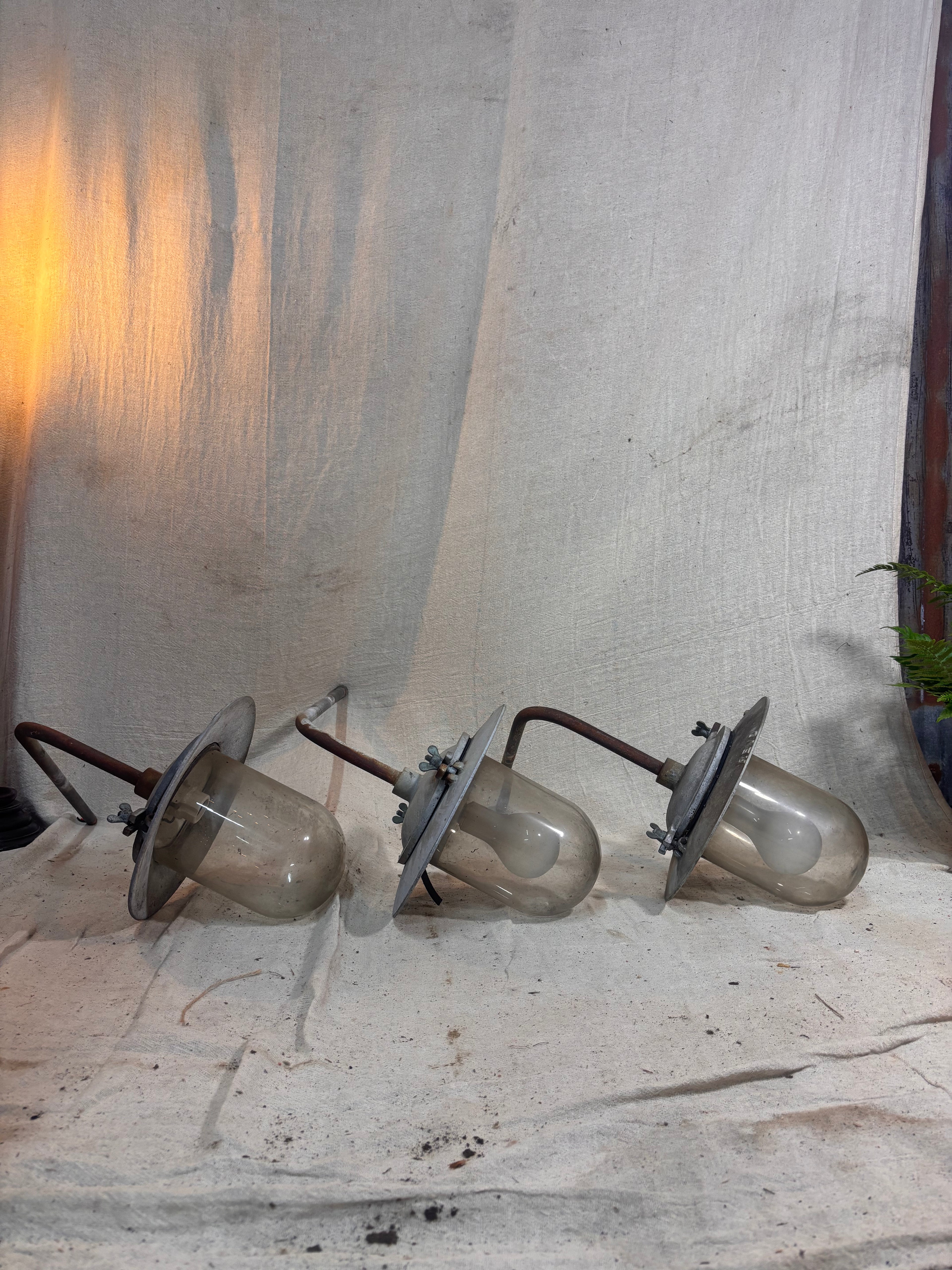 3 industrial light fittings laid on the floor