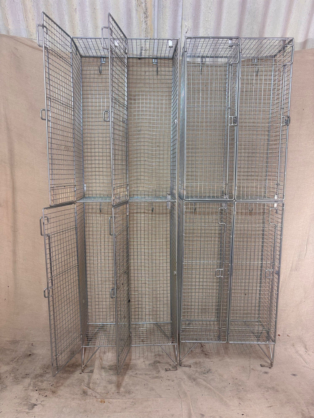Set of metal wire storage cages against a beige wall.
